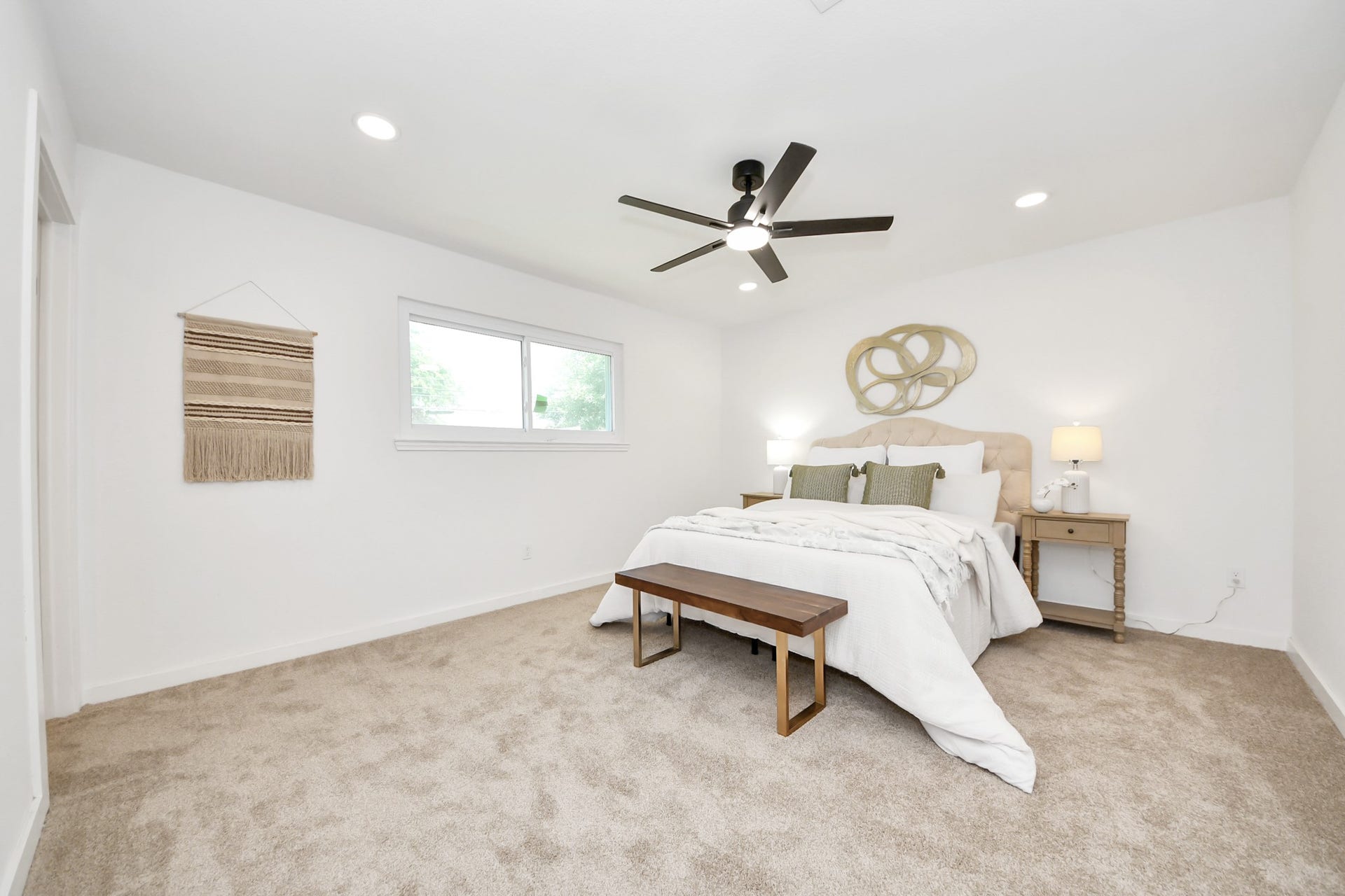 5946 Willowbend Boulevard, Houston, TX 77096 Spacious primary bedroom with plush carpeting, modern ceiling fan, and abundant natural light.
