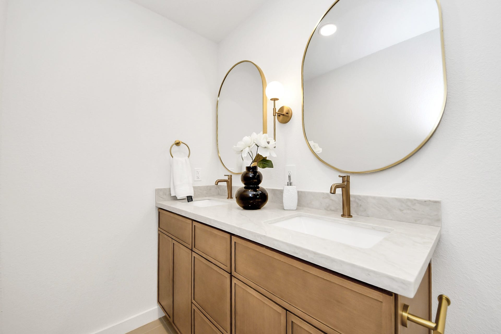 5946 Willowbend Boulevard, Houston, TX 77096 Designer double vanity with custom cabinetry, quartz countertops, elegant mirrors, and modern lighting.