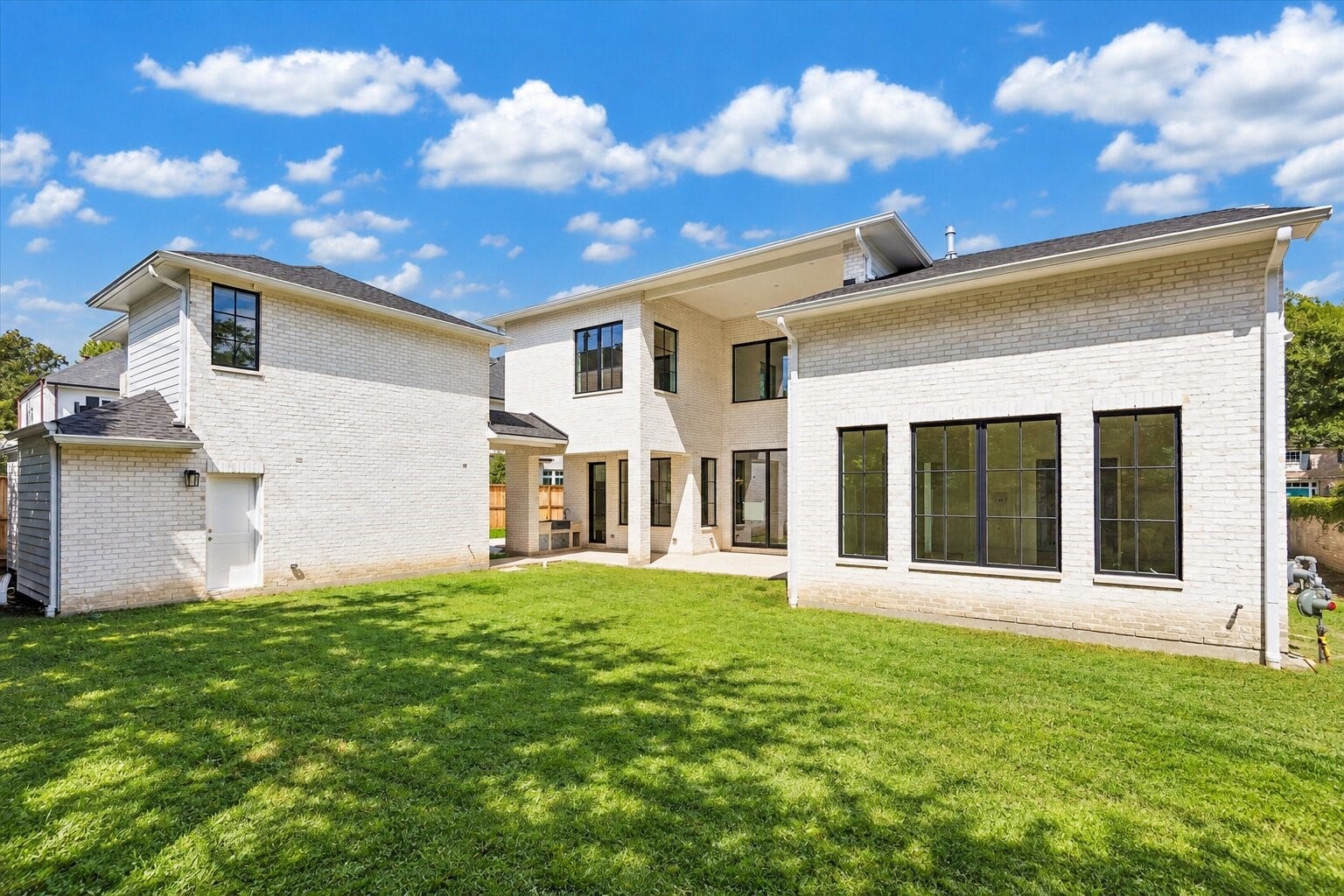 6011 Stones Throw Road, Houston, TX 77057 Expansive backyard offers lush greenery and a covered summer kitchen, ideal for outdoor entertaining.