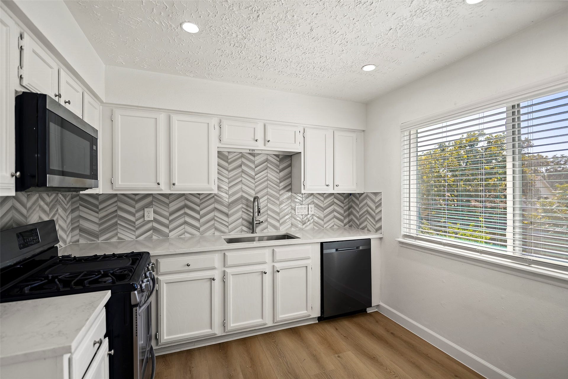 19331 Diversion Drive, Tomball, TX 77375 Updated kitchen featuring quartz countertops, white cabinetry, and stainless steel appliances.