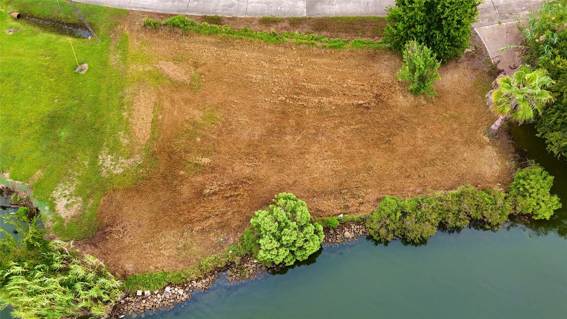 0000 Scenic Drive, Dickinson, TX 77539 Aerial view of the waterfront lot showcasing the propertys layout, road frontage, & direct water frontage.