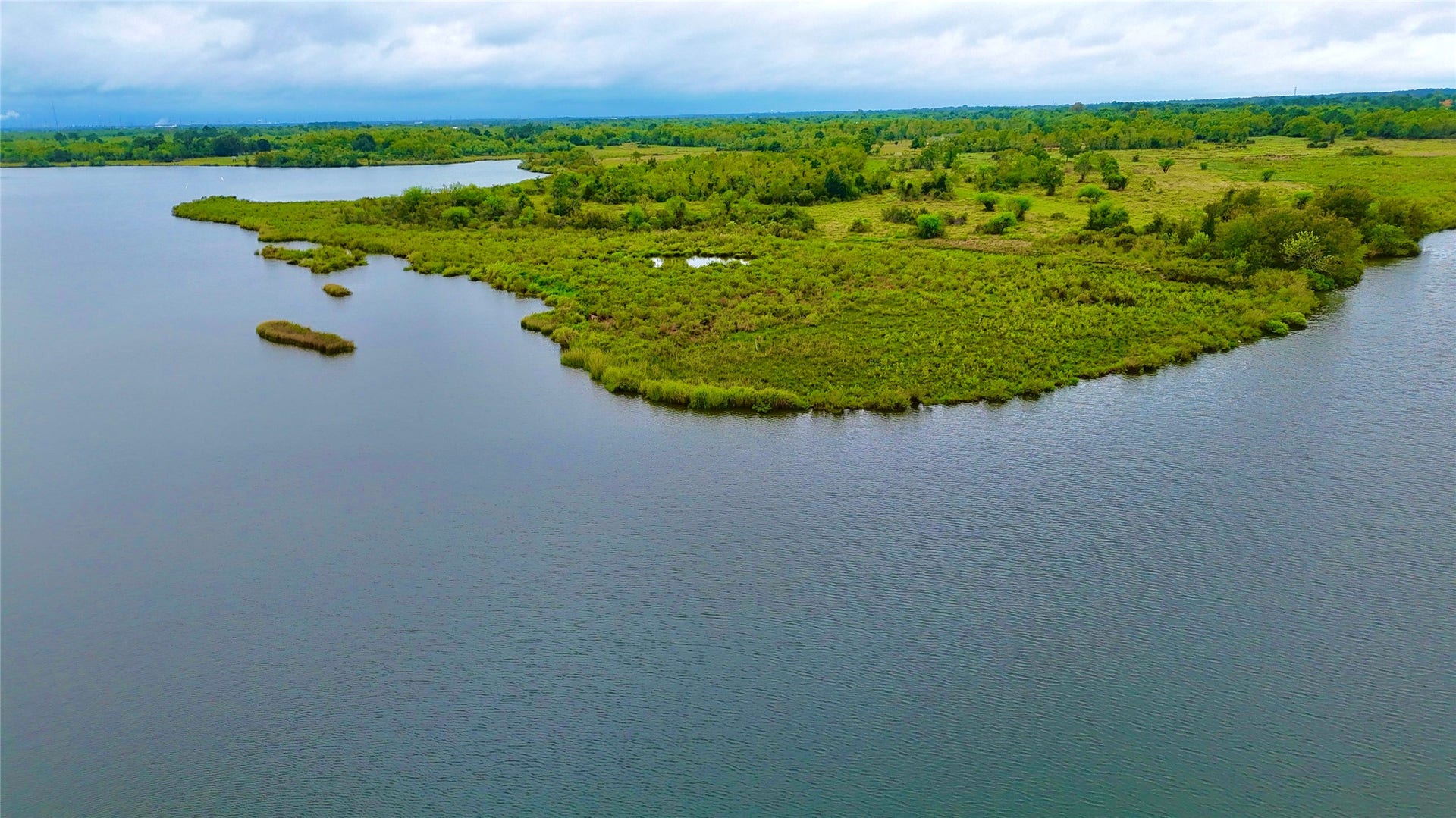0000 Scenic Drive, Dickinson, TX 77539 A closer aerial capture of the marshlands and green natural peninsula across the water from the property.