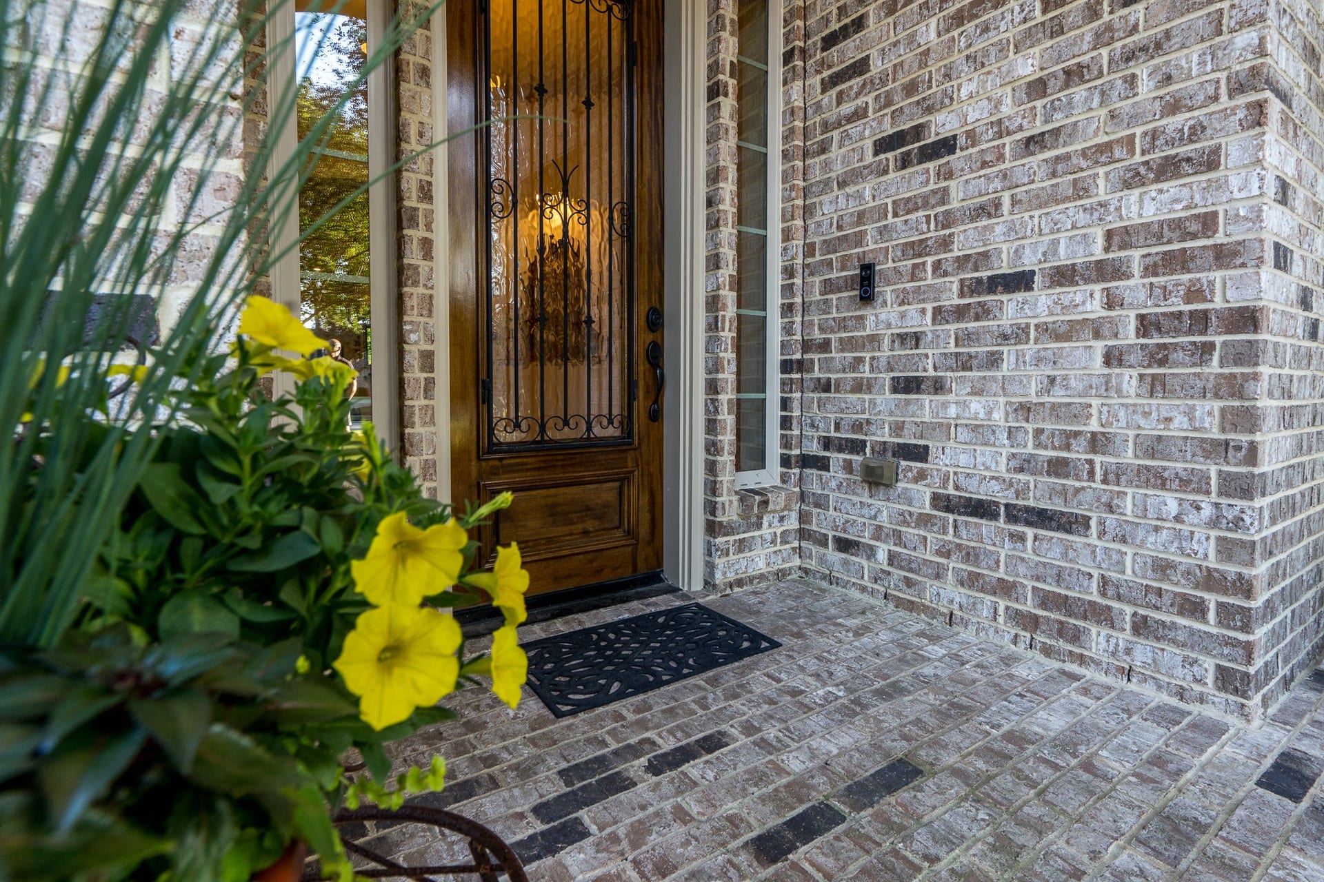 13807 Oak Fair Bend, Cypress, TX 77429 WHERE ELEGANCE BEGINS AT THE FRONT DOOR! A beautifully crafted wood entry door with exquisite wrought-iron detailing welcomes you home, framed by timeless brickwork and charming sidelights. Vibrant seasonal blooms add a delightful touch of color, offering a glimpse of the warmth, sophistication, and attention to detail awaiting inside this exceptional J. Patrick semi-custom home!