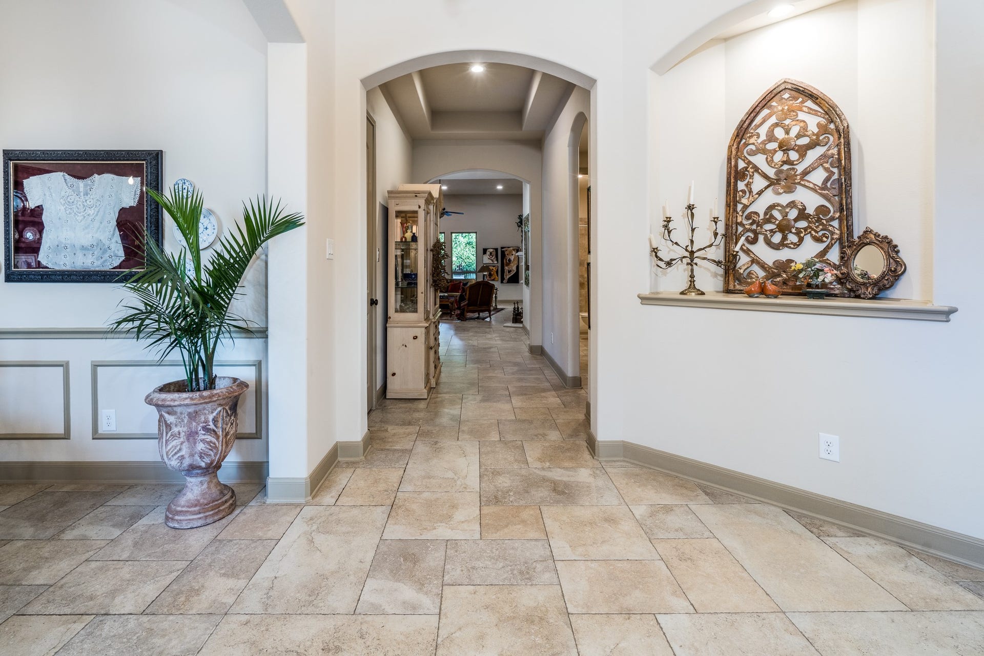 13807 Oak Fair Bend, Cypress, TX 77429 ELEGANCE FLOWS THROUGH EVERY DETAIL! Beautiful arched doorways, timeless travertine flooring, and abundant natural light create a warm, inviting atmosphere. This graceful hallway offers a seamless transition between living spaces, showcasing the thoughtful architectural design and understated sophistication of this exceptional J. Patrick home!