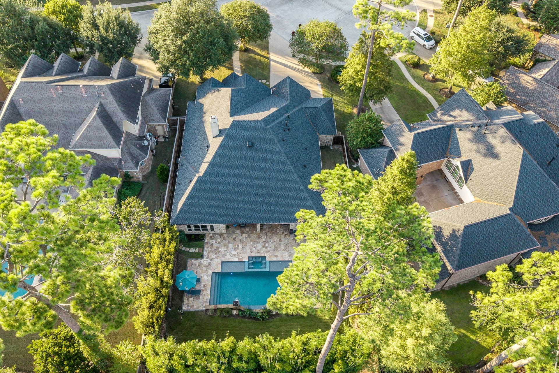 13807 Oak Fair Bend, Cypress, TX 77429 A Stunning Birds-Eye View of Luxury, Privacy, and Peace of Mind! This spectacular aerial perspective showcases the home's beautiful architectural design, new roof installed in 2024, and breathtaking backyard pool oasis. Surrounded by mature trees and lush landscaping, the property offers a wonderful sense of privacy while highlighting the expansive natural stone patio, sparkling pool, and inviting outdoor living spaces. A remarkable combination of timeless elegance and resort-inspired living!