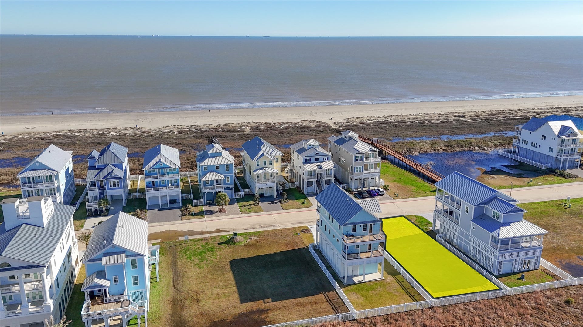 This elevated perspective illustrates just how close the homesite is to the shoreline, with only the neighboring row of residences separating the property from the Gulf of Mexico. The lots location within the gated Preserve at Grand Beach offers the opportunity to design around sunrise views toward the Gulf while enjoying the privacy and more intimate atmosphere of this secluded East End community.