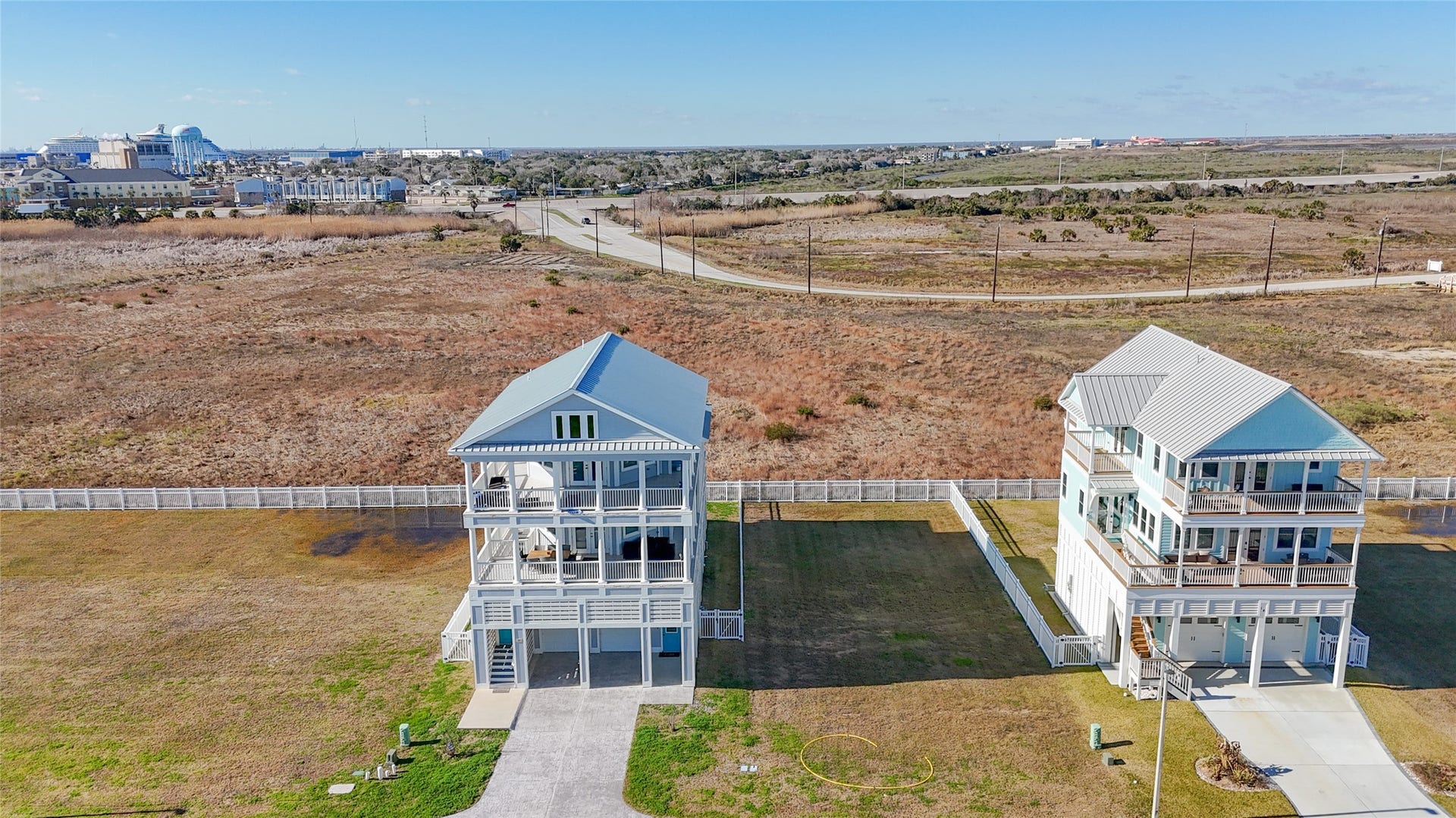 This view from the rear illustrates one of the propertys most distinctive advantages: an unusually open setting behind the homesite with no immediate rear neighbor. That unobstructed exposure creates opportunities to orient decks, balconies and outdoor living areas toward expansive western views and colorful Galveston sunsets, while the opposite side of a future residence can be designed to capitalize on sunrise views toward the Gulf.