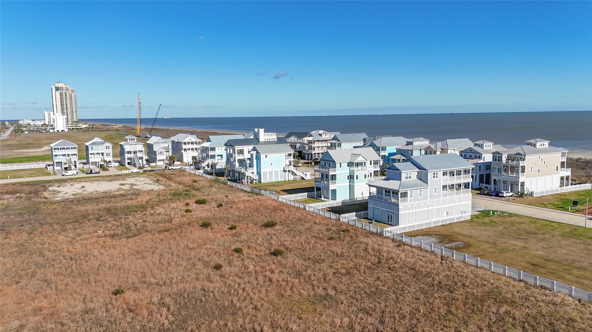 Aerial view shows the homesite in relation to the surrounding East End landscape, with the Gulf and established Preserve at Grand Beach residences nearby. Unlike many densely developed Galveston building sites, this property benefits from an open rear exposure with no back neighbor. The combination creates the potential for a custom home designed around views in both directionsGulf sunrises to the east and expansive sunsets to the west.