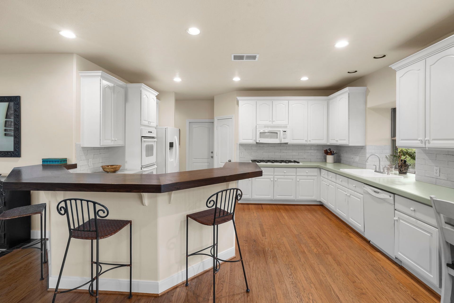 39 Rippling Creek Drive, Sugar Land, TX 77479 The spacious kitchen is equipped with a gas cooktop, double ovens, and a built-in microwave, offering plenty of options for preparing meals.
