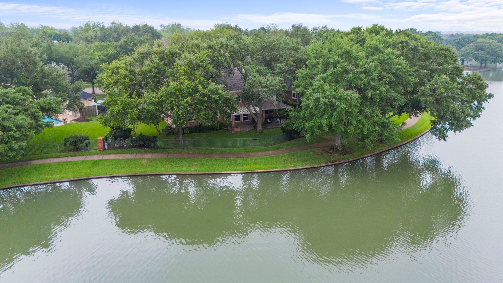 39 Rippling Creek Drive, Sugar Land, TX 77479 An aerial view highlights the paved walking trail just steps from your back door, winding around the lake.