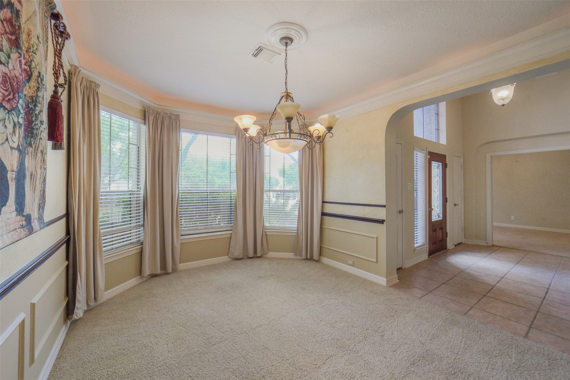 21603 Statfield Glen, Katy, TX 77450 The formal living room features a bay window, complemented by elegant crown, chair, and picture-frame molding, all illuminated by a stunning chandelier.