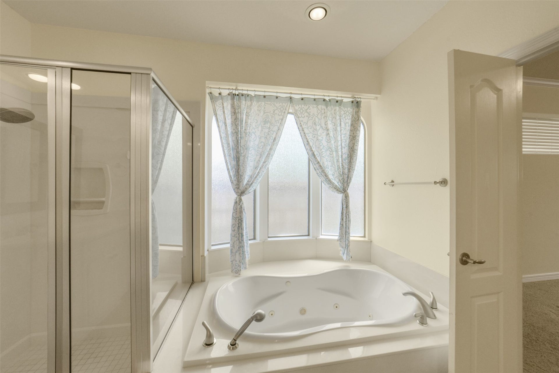 21603 Statfield Glen, Katy, TX 77450 Jetted soaker tub nestled in a frosted glass bay window, accompanied by a large, glass-enclosed shower.