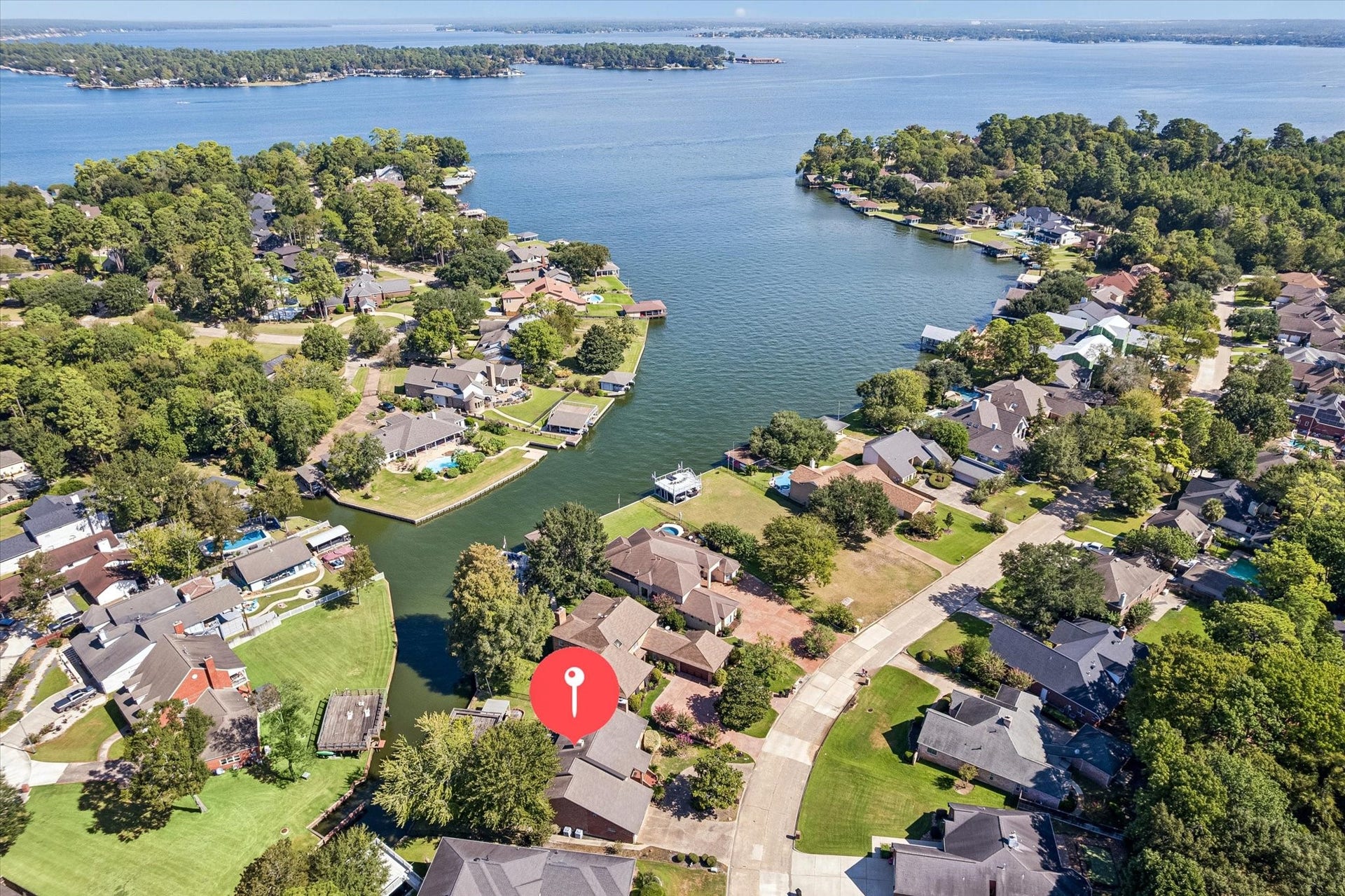 114 Lakeside Drive showcasing its waterfront setting in gated April Sound on Lake Conroe along a protected cove with private waterfront and boathouse.