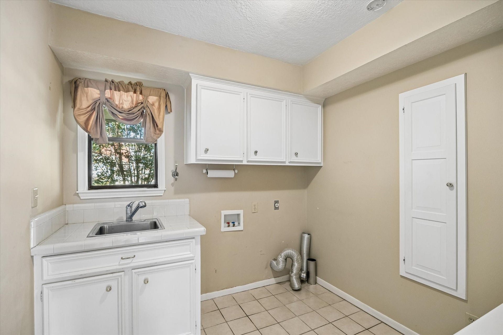 Dedicated laundry room provides cabinetry and storage for everyday household needs.