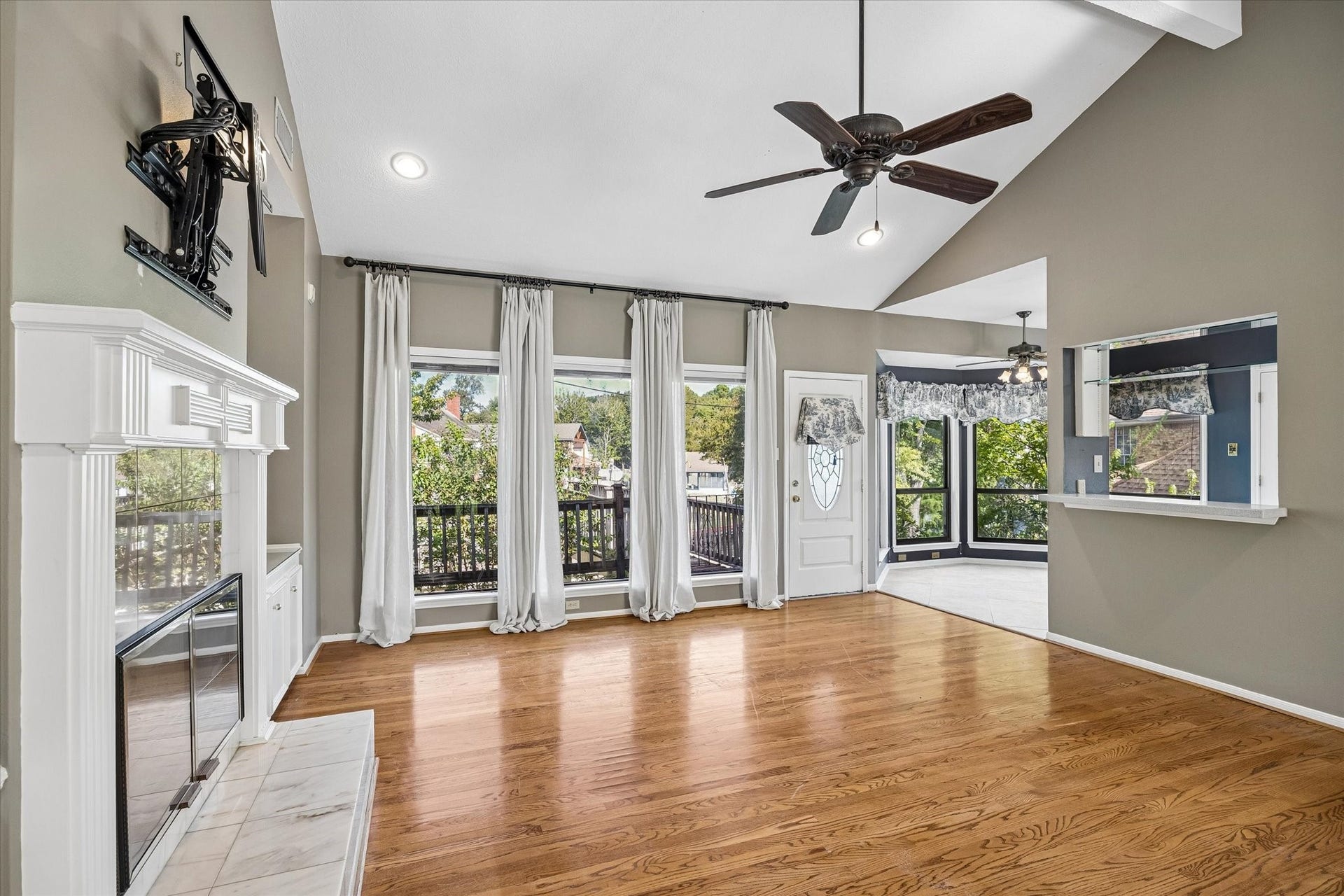 Another view of the upstairs living room, where large windows bring in natural light and views of the outdoors.