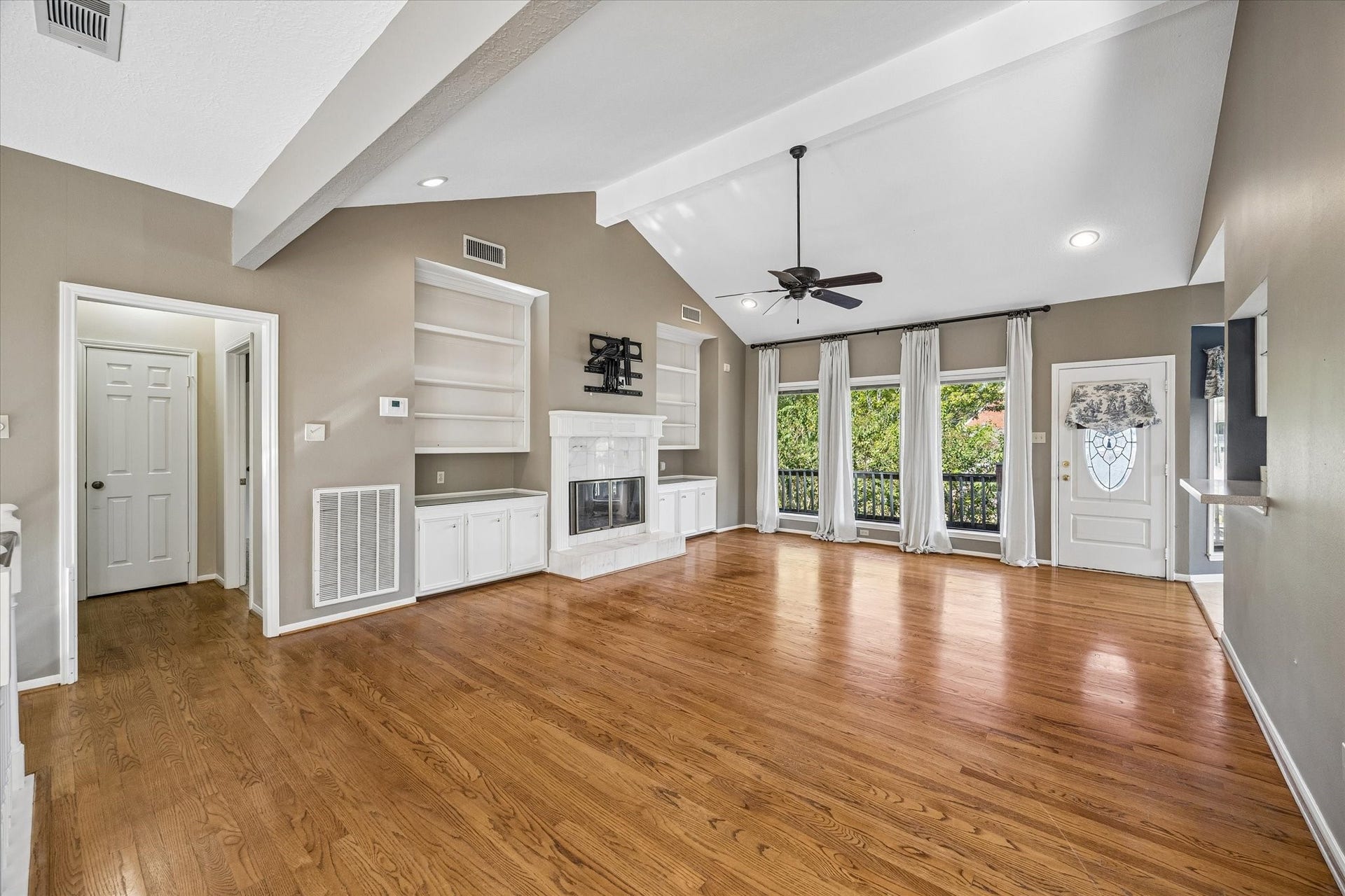 Upstairs living room features warm wood floors, a fireplace and abundant natural light.