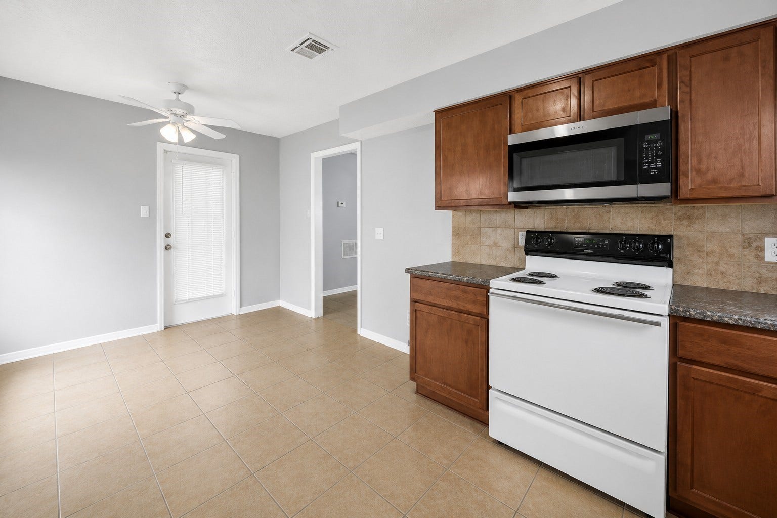 1707 Stone Lake Drive, Missouri City, TX 77489 Bright kitchen and dining area featuring ample cabinet space, tile flooring, and convenient garage access.