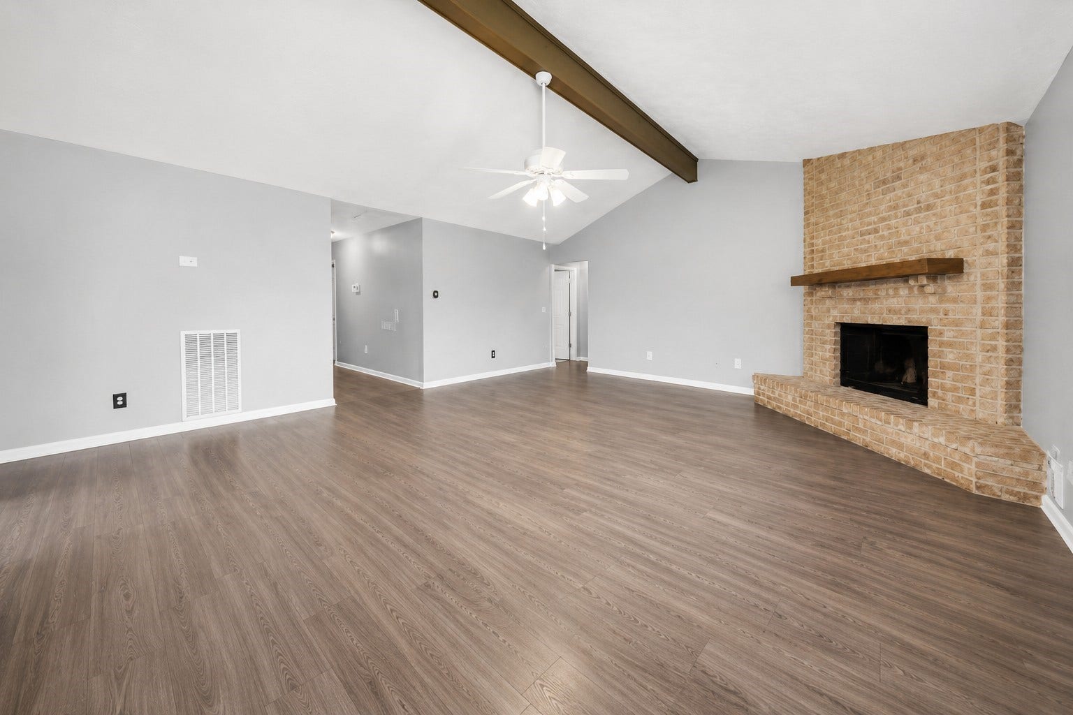 1707 Stone Lake Drive, Missouri City, TX 77489 Another view of the spacious living area showcasing the brick fireplace and vaulted ceiling with exposed wood beam.