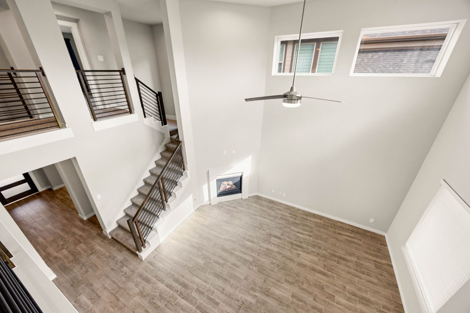 3815 Favor Forest Court, Katy, TX 77494 From the upstairs catwalk, this view showcases the dramatic two-story living area below, anchored by the fireplace and soaring windows.