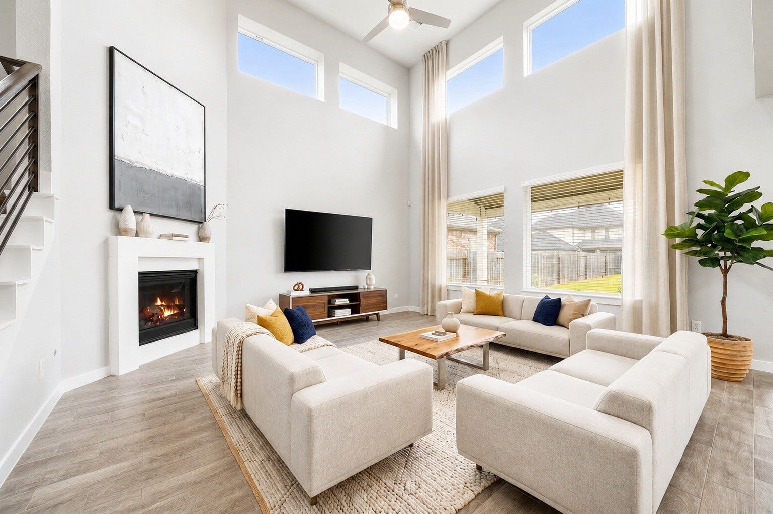 3815 Favor Forest Court, Katy, TX 77494 Soaring two-story windows flood the living area with natural light, creating a dramatic, airy backdrop for the cozy fireplace below and the open catwalk above. Virtually staged.