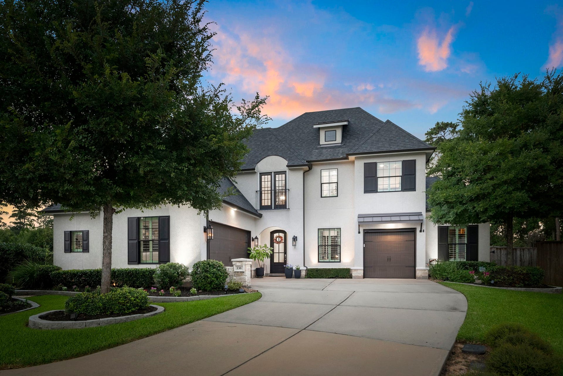 A welcoming French Country exterior creates an elegant first impression with mature landscaping, a wide drive, and timeless architectural detail. The homes refined presence immediately reflects its luxury positioning.