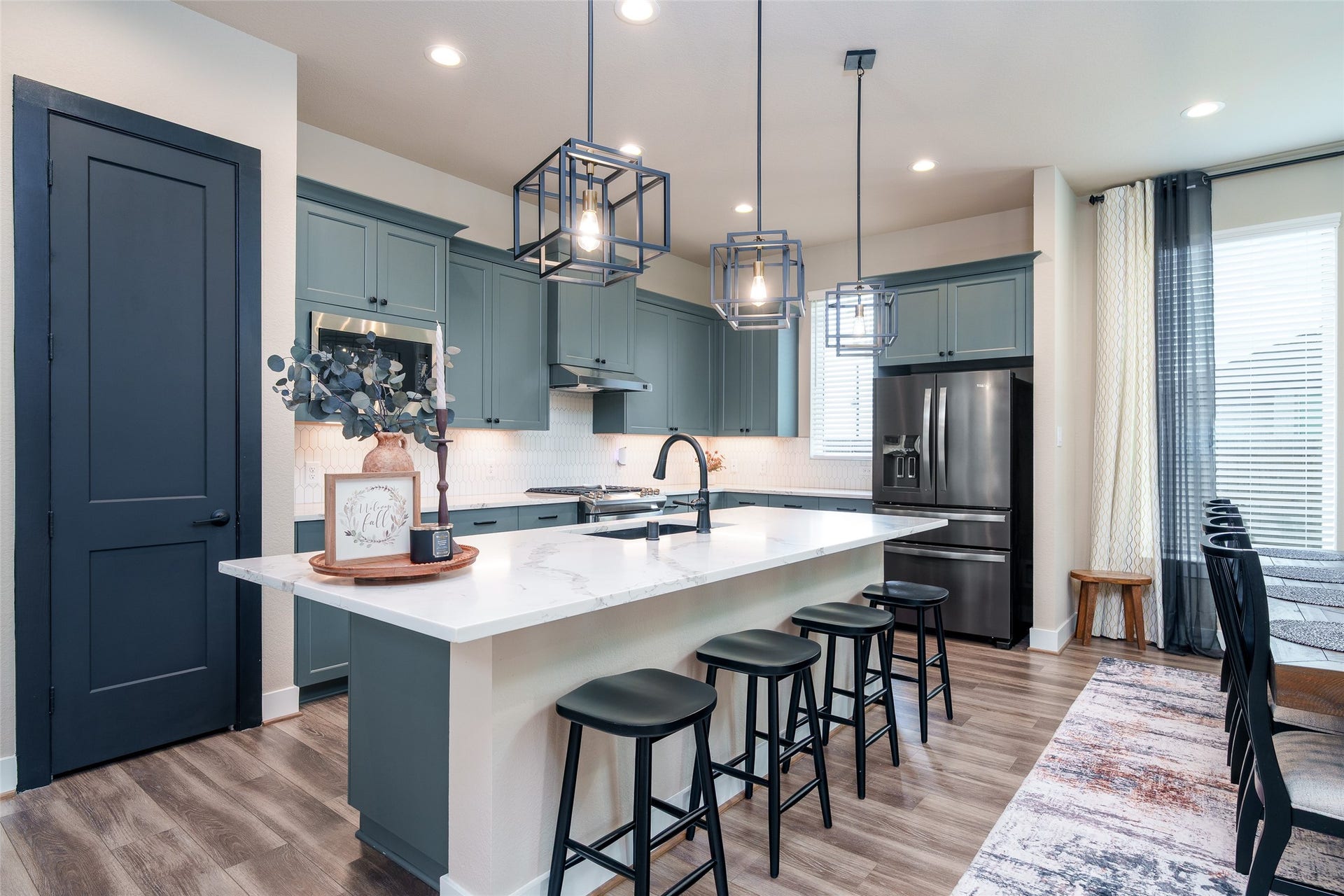 3348 Voda Bend Drive, Katy, TX 77493 The kitchen is a chefs dream, featuring custom painted cabinets, sleek, upgraded granite countertops, a spacious kitchen island, and modern pendant lighting that beautifully illuminates the space.