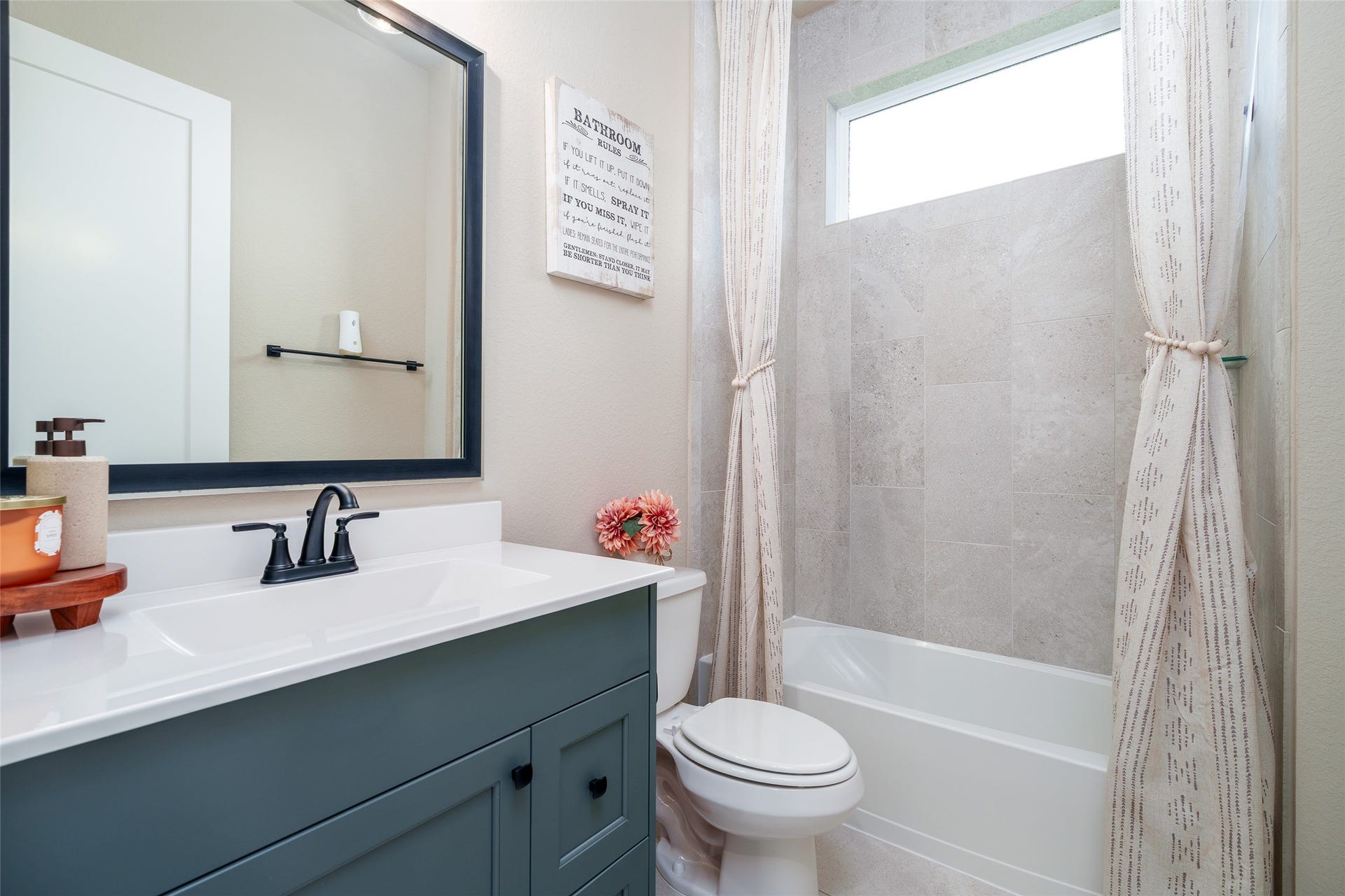 3348 Voda Bend Drive, Katy, TX 77493 This well-appointed bathroom features a convenient shower/tub combo, a sleek custom painted vanity with a framed mirror, and a modern toilet, providing both style and functionality.