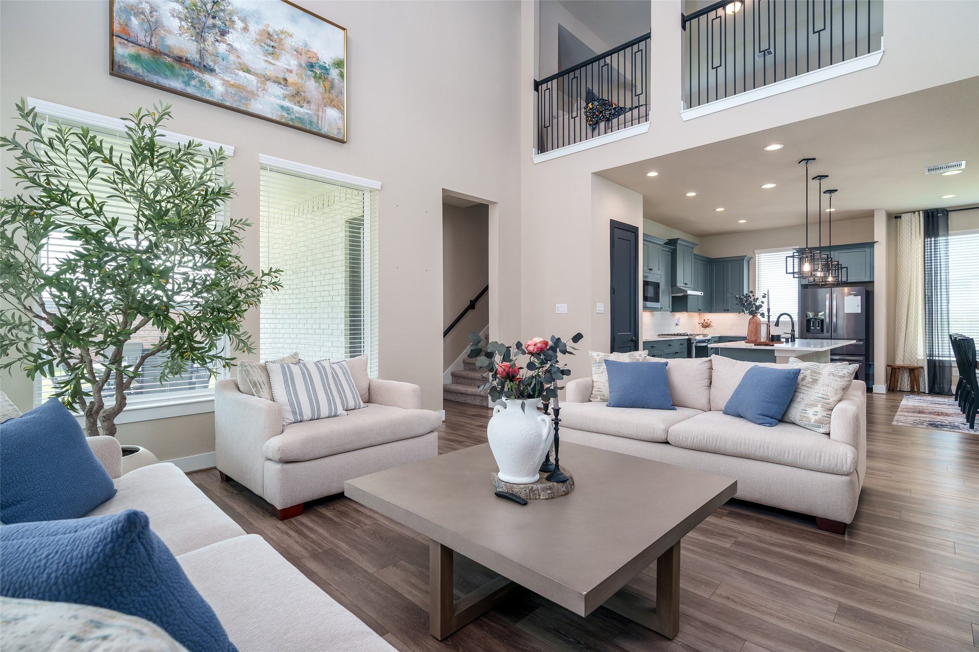 3348 Voda Bend Drive, Katy, TX 77493 The spacious living room boasts soaring high ceilings, beautiful LVP flooring, and large windows with privacy blinds that fill the space with natural light while maintaining comfort and seclusion.