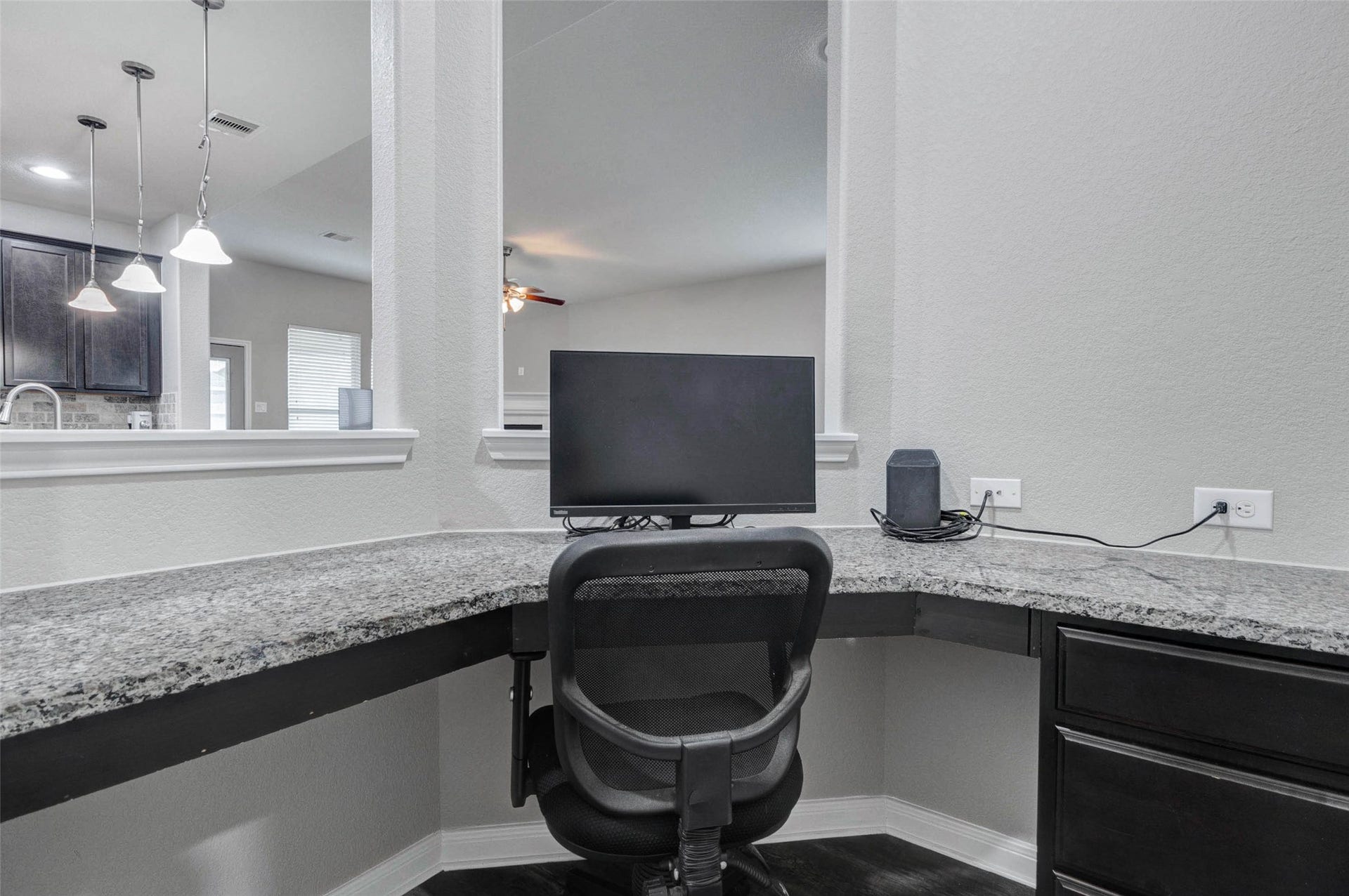 30218 Creekside Drive, Brookshire, TX 77423 A home office nook with granite countertops and ample workspace, perfectly situated near the kitchen and overlooking the living area is perfect for convenience and connectivity.