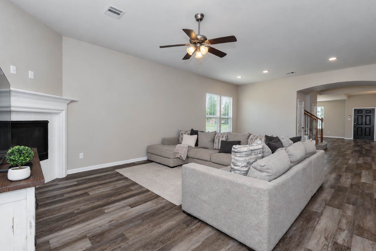 30218 Creekside Drive, Brookshire, TX 77423 Spacious living room with wood-like flooring and abundant natural light. The room is large enough for all your furniture, perfect for relaxation and gatherings.