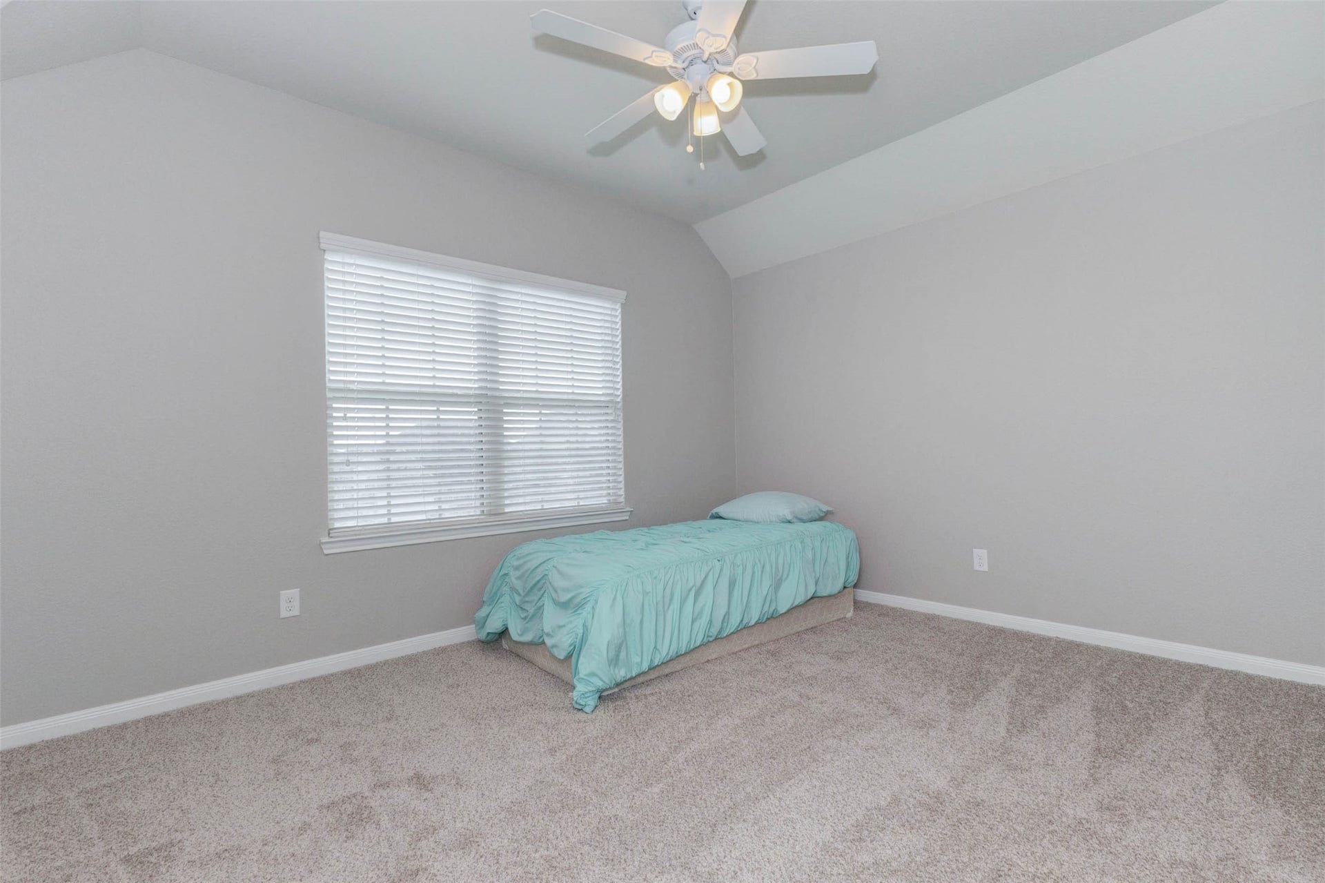 30218 Creekside Drive, Brookshire, TX 77423 Bright and airy secondary bedroom featuring a vaulted ceiling, plush carpeting, and ample natural light streaming through a large window with blinds. This one is connected by the Jack-n-Jill bathroom.