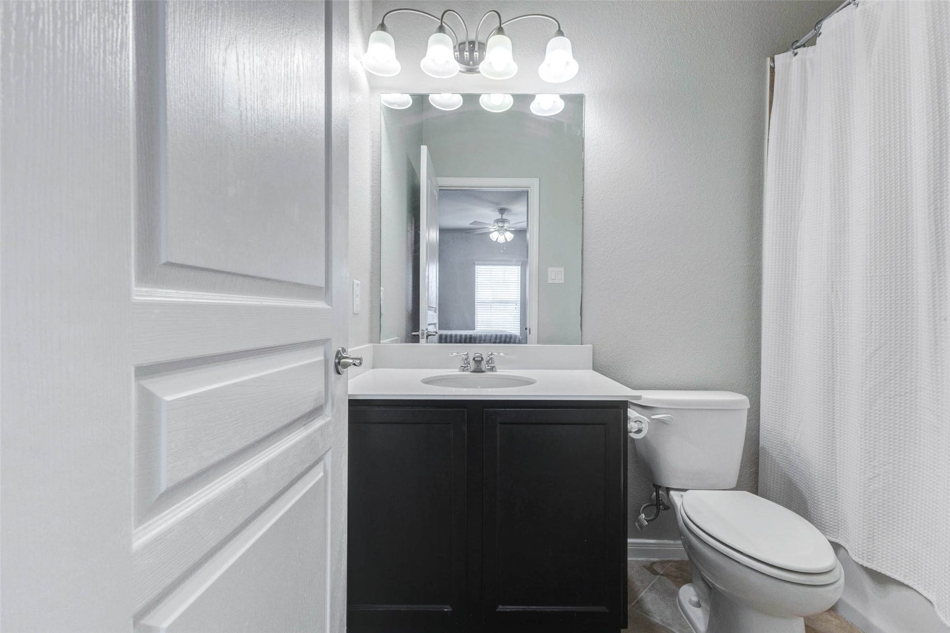30218 Creekside Drive, Brookshire, TX 77423 The en-suite bathroom featuring a sleek vanity with a large mirror, modern lighting, and a pristine shower area, creating a bright and inviting space.