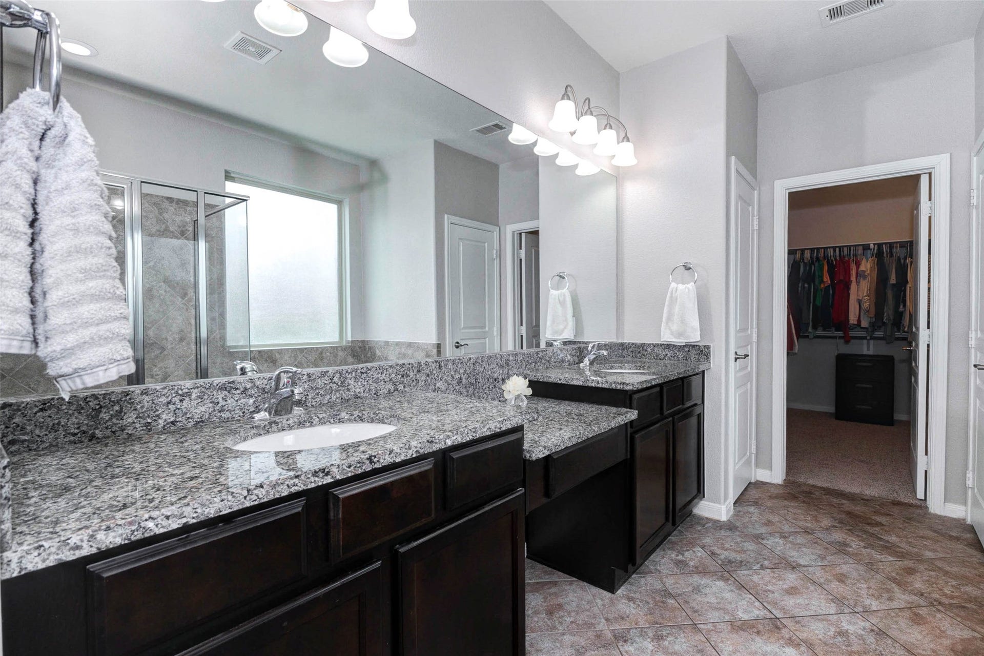 30218 Creekside Drive, Brookshire, TX 77423 Elegant master bathroom featuring dual granite vanities, a spacious walk-in closet, and a glass-enclosed shower.