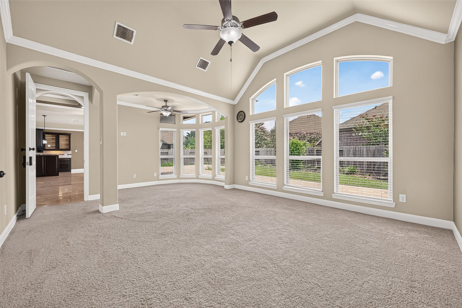 27818 Tamara Branch Lane, Katy, TX 77494 Primary Bedroom: Privately situated at the rear of the home, the luxurious primary suite offers high ceilings, plush carpet, a cozy sitting area, arched walkways, and a wall of windows that brings in abundant natural light.