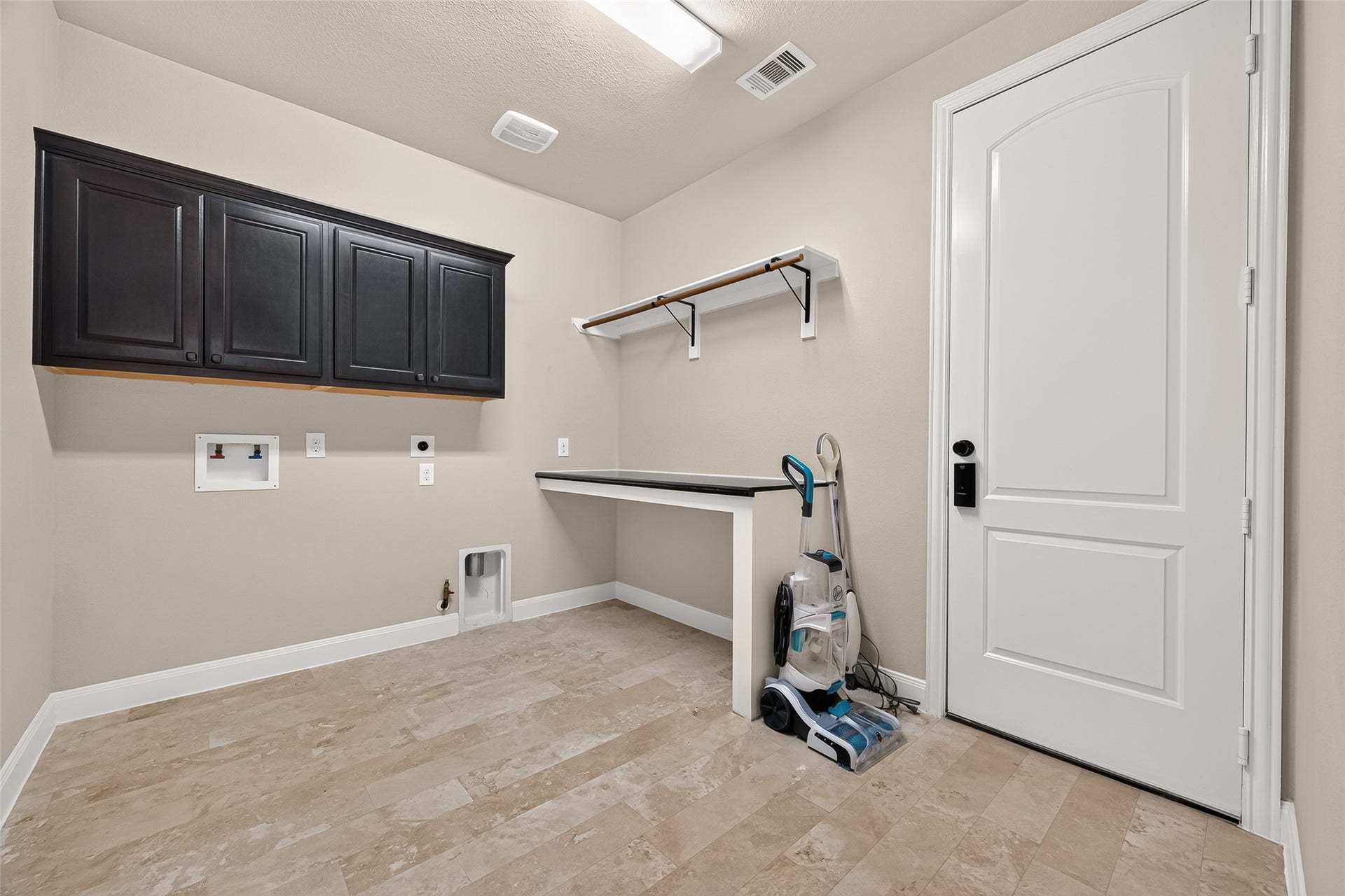 27818 Tamara Branch Lane, Katy, TX 77494 Downstairs Laundry Room: The spacious main laundry room is thoughtfully designed with built-in countertops, hanging racks, and extra cabinets for exceptional storage.