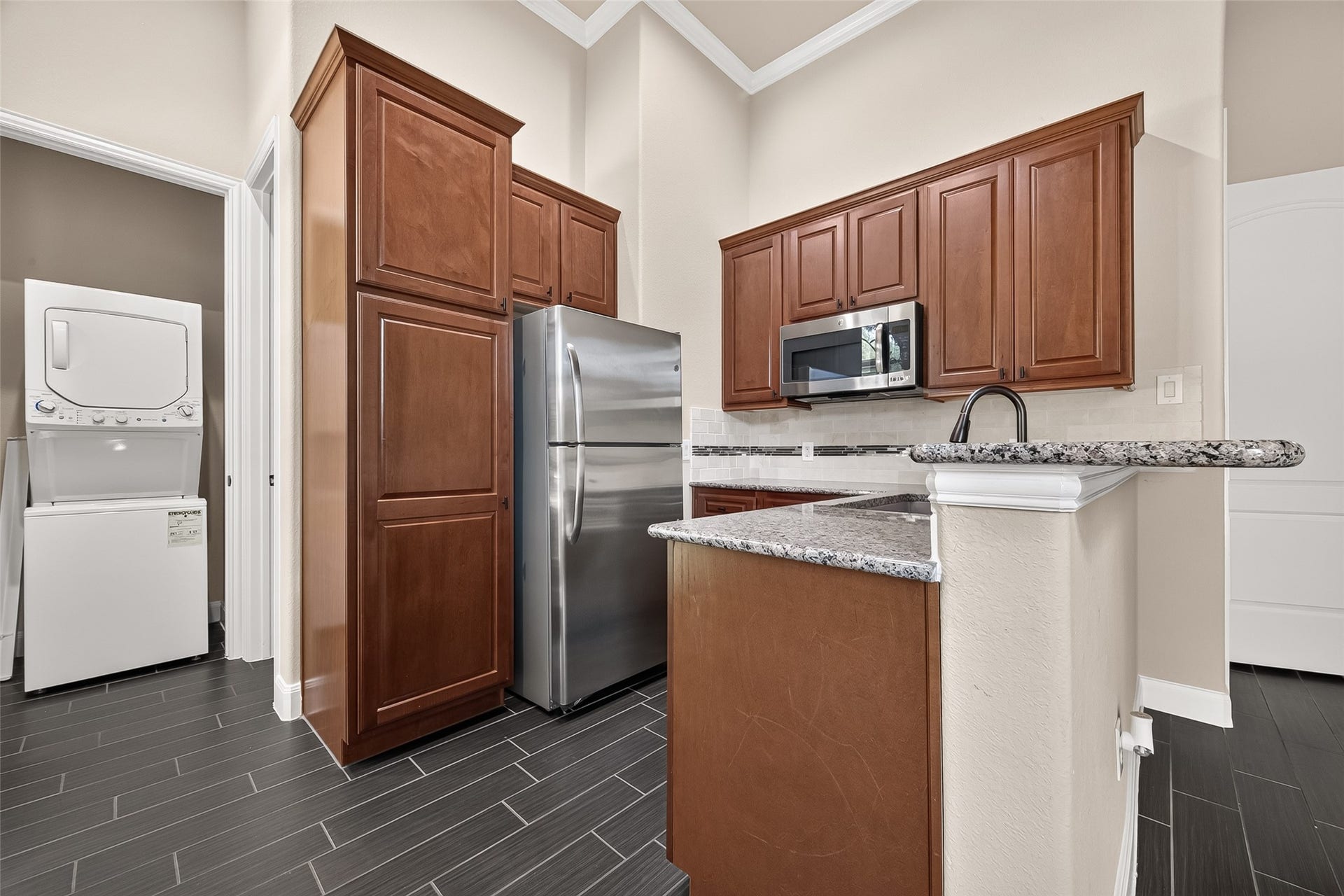27818 Tamara Branch Lane, Katy, TX 77494 Kitchenette: kitchenette featuring granite countertops, stainless steel appliances, refrigerator, electric cooktop, eat-up bar, beautiful cabinetry, a private bedroom with en-suite bath, and its own laundry area!