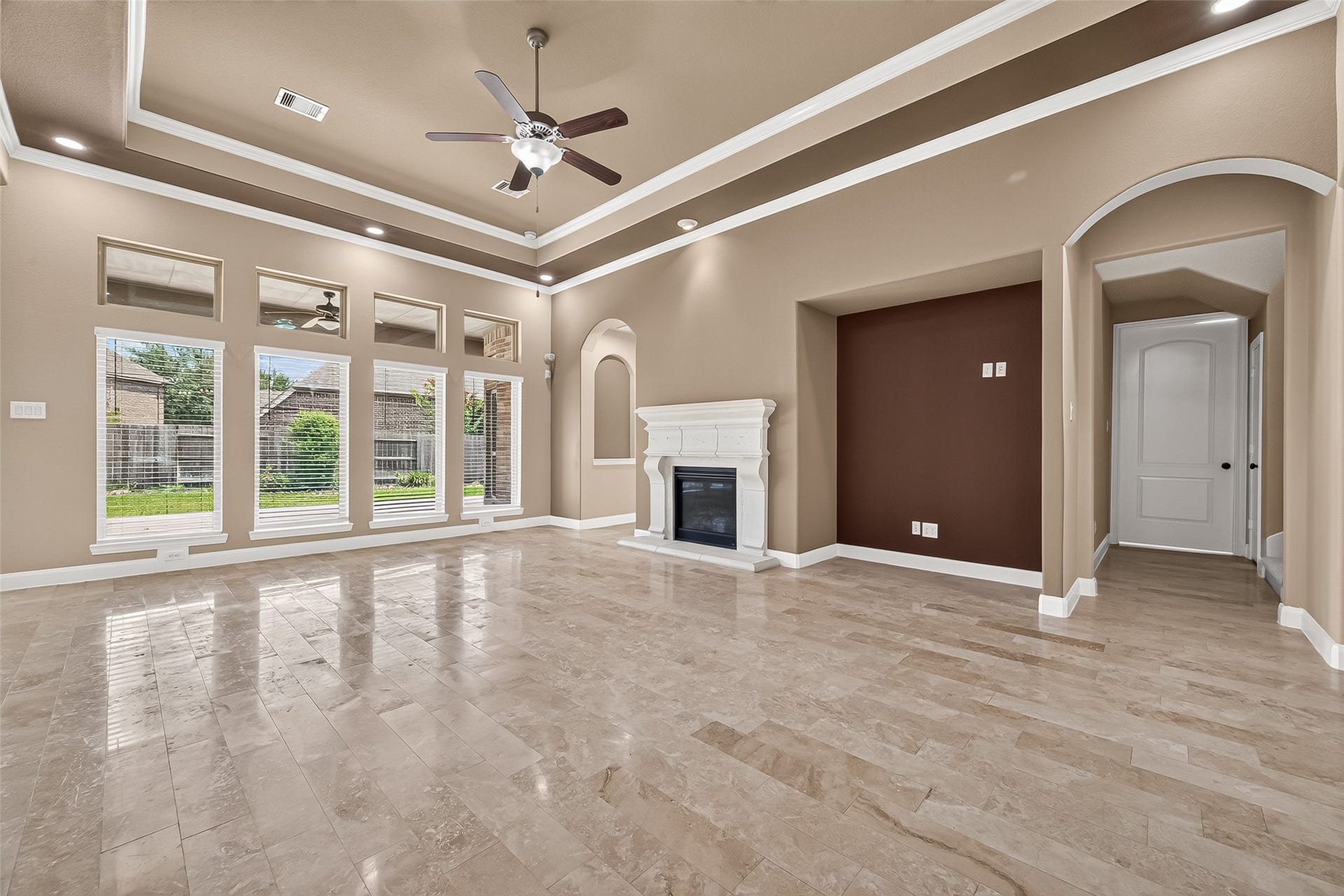 27818 Tamara Branch Lane, Katy, TX 77494 Family Room: The spacious family room boasts a cast-stone fireplace, tray ceilings, and a dramatic wall of windows that fills the home with natural light and views of the backyard patio.