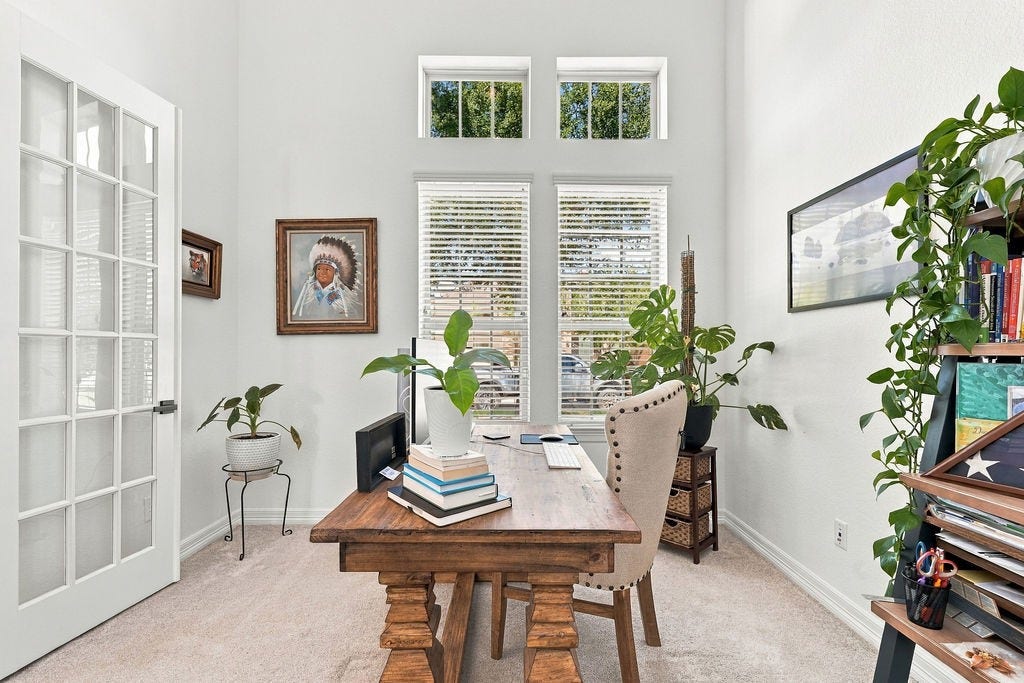 9918 Hubble Drive, Iowa Colony, TX 77583 Bright and inviting home office with high ceilings, large windows, and French doors, featuring stylish decor and abundant natural light.