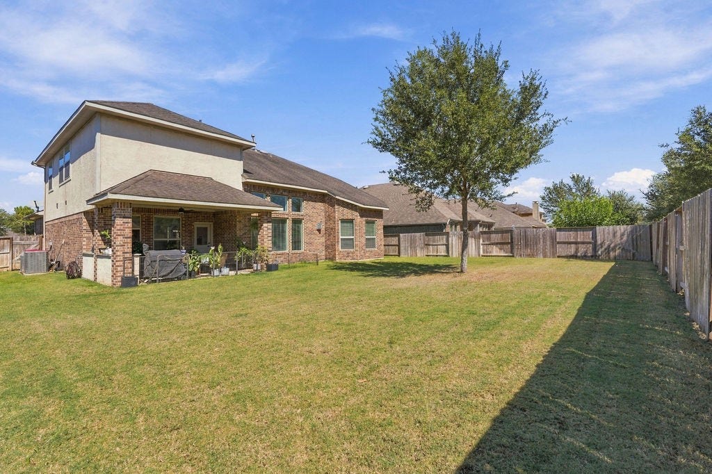 9918 Hubble Drive, Iowa Colony, TX 77583 Spacious backyard with a well-maintained lawn, perfect for outdoor activities, featuring a covered patio ideal for relaxation and entertaining.