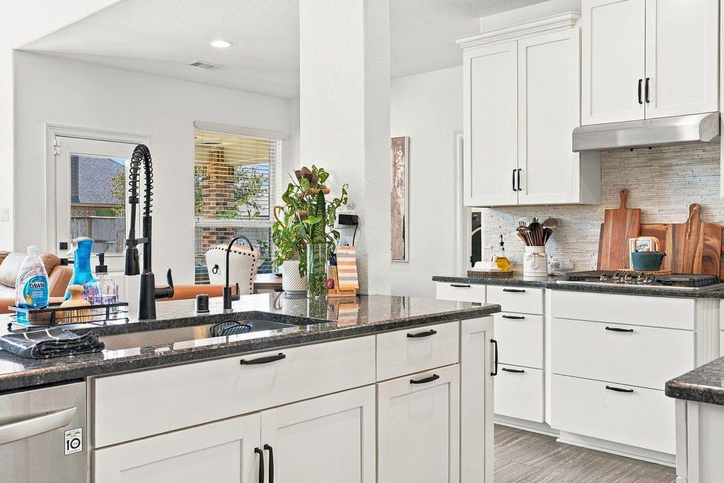 9918 Hubble Drive, Iowa Colony, TX 77583 Bright kitchen with sleek white cabinetry, modern fixtures, and a spacious island, perfect for culinary enthusiasts.