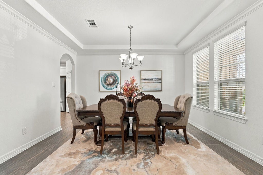 9918 Hubble Drive, Iowa Colony, TX 77583 Elegant dining room featuring a sophisticated chandelier, large enough for 8-10 chair dining set and has abundant natural light from large windows.