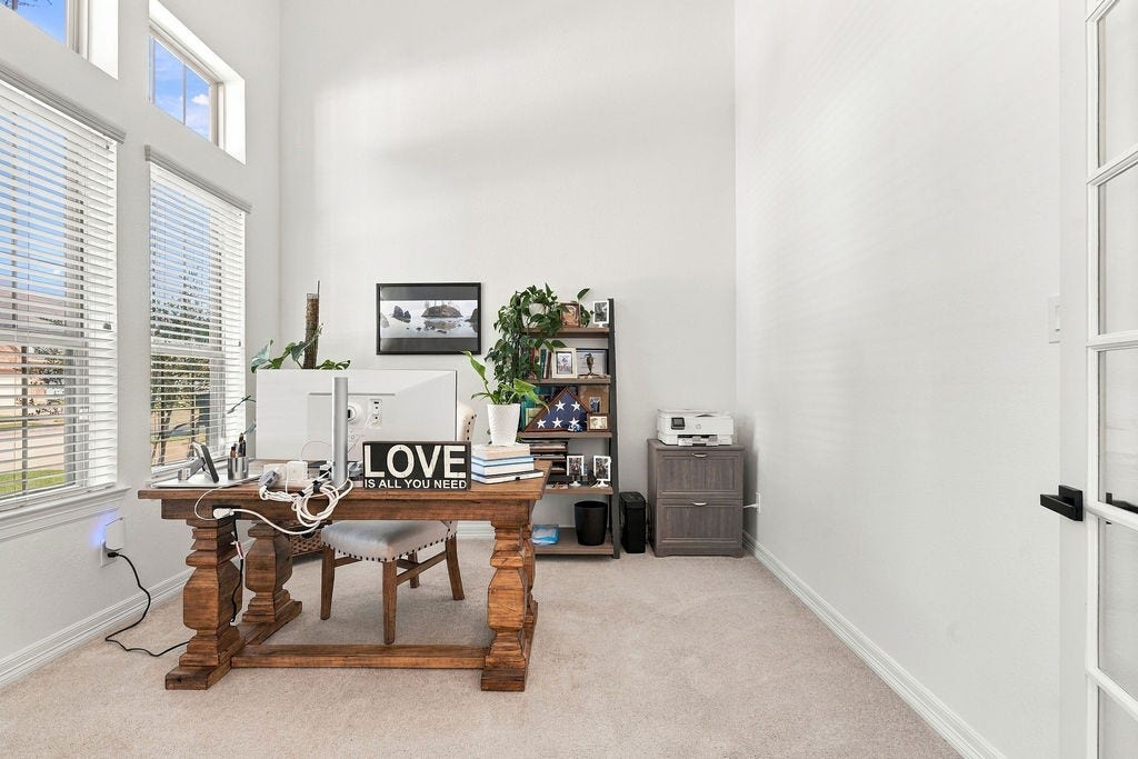 9918 Hubble Drive, Iowa Colony, TX 77583 Bright and inviting office space with high ceilings, large windows for natural light, and elegant wood furniture creating a productive work environment.