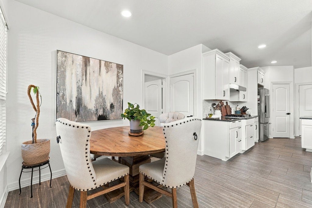 9918 Hubble Drive, Iowa Colony, TX 77583 Bright and inviting kitchen with modern white cabinetry, stainless steel appliances, and a cozy dining area featuring a round wooden table and upholstered chairs. Seller is selling this set also.