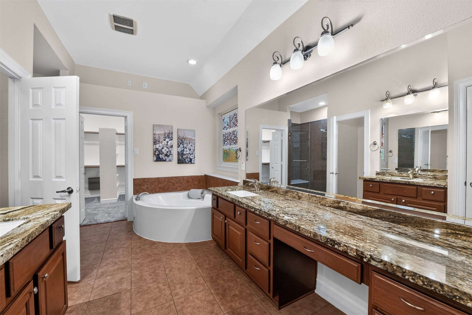 12009 Cedar Creek Drive, Pearland, TX 77584 The primary bathroom offers granite countertops, a linen closet, brush nickel hardware, convenient "medicine" cabinets, and a large luxurious jetted tub with stained glass block window.