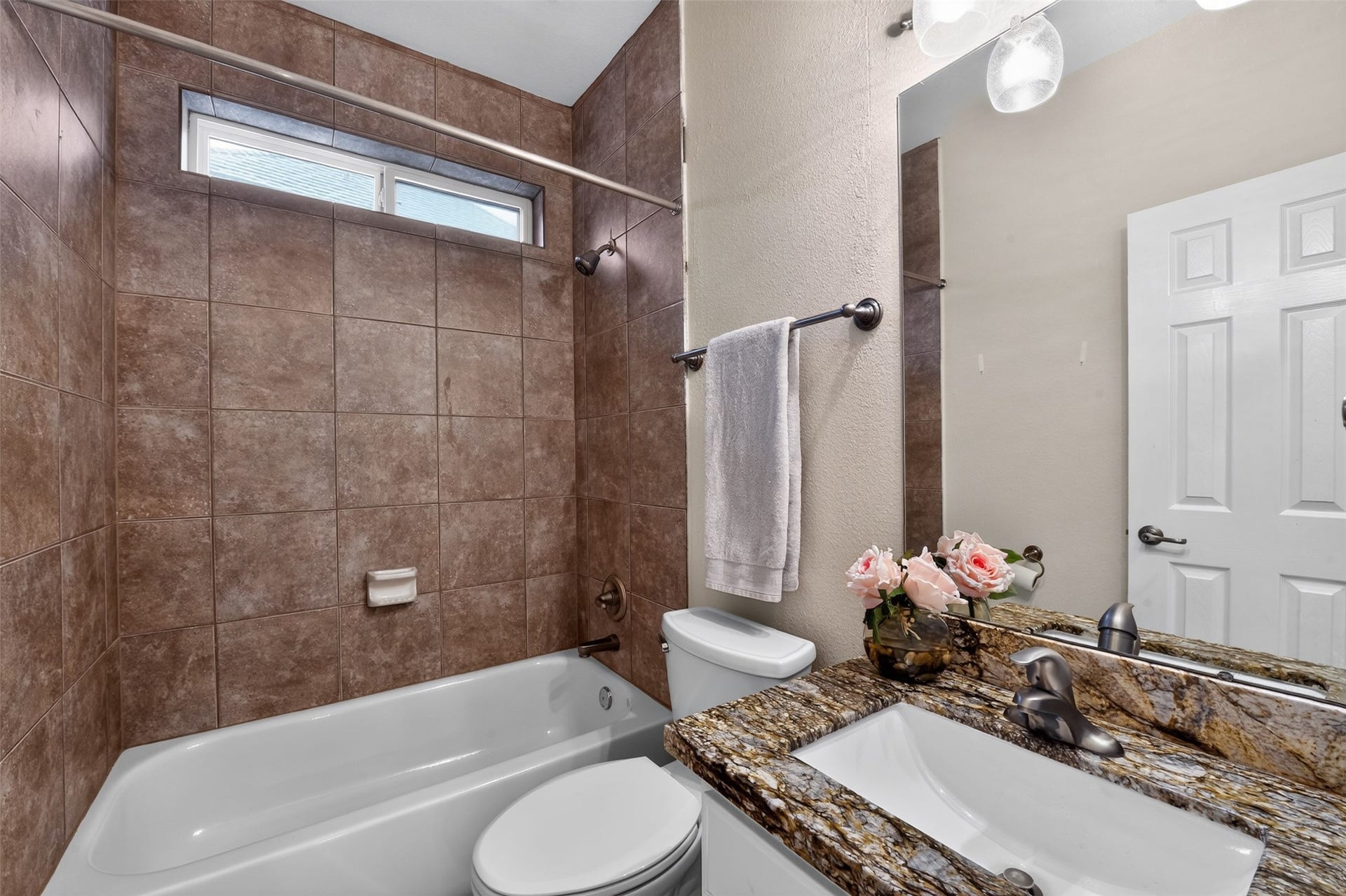 12009 Cedar Creek Drive, Pearland, TX 77584 Secondary bathroom with tiled (to ceiling) tub/shower, and a gorgeous granite vanity countertop. Updated brush nickel hardware and updated lighting too!