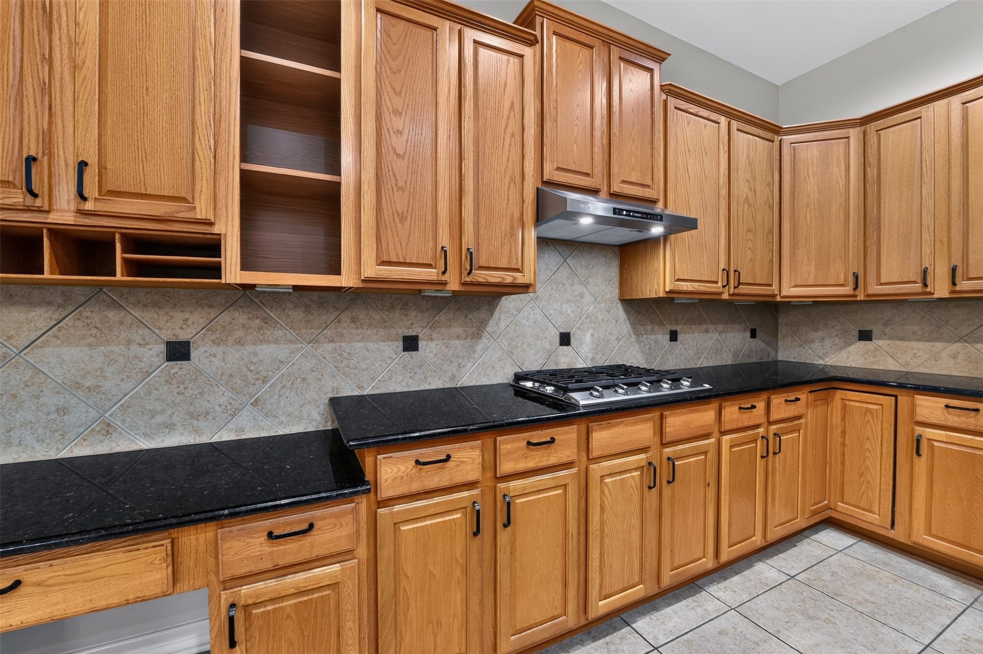 12009 Cedar Creek Drive, Pearland, TX 77584 Built-in chef's desk and fabulous cabinet storage! Granite countertops and tiled backsplash.