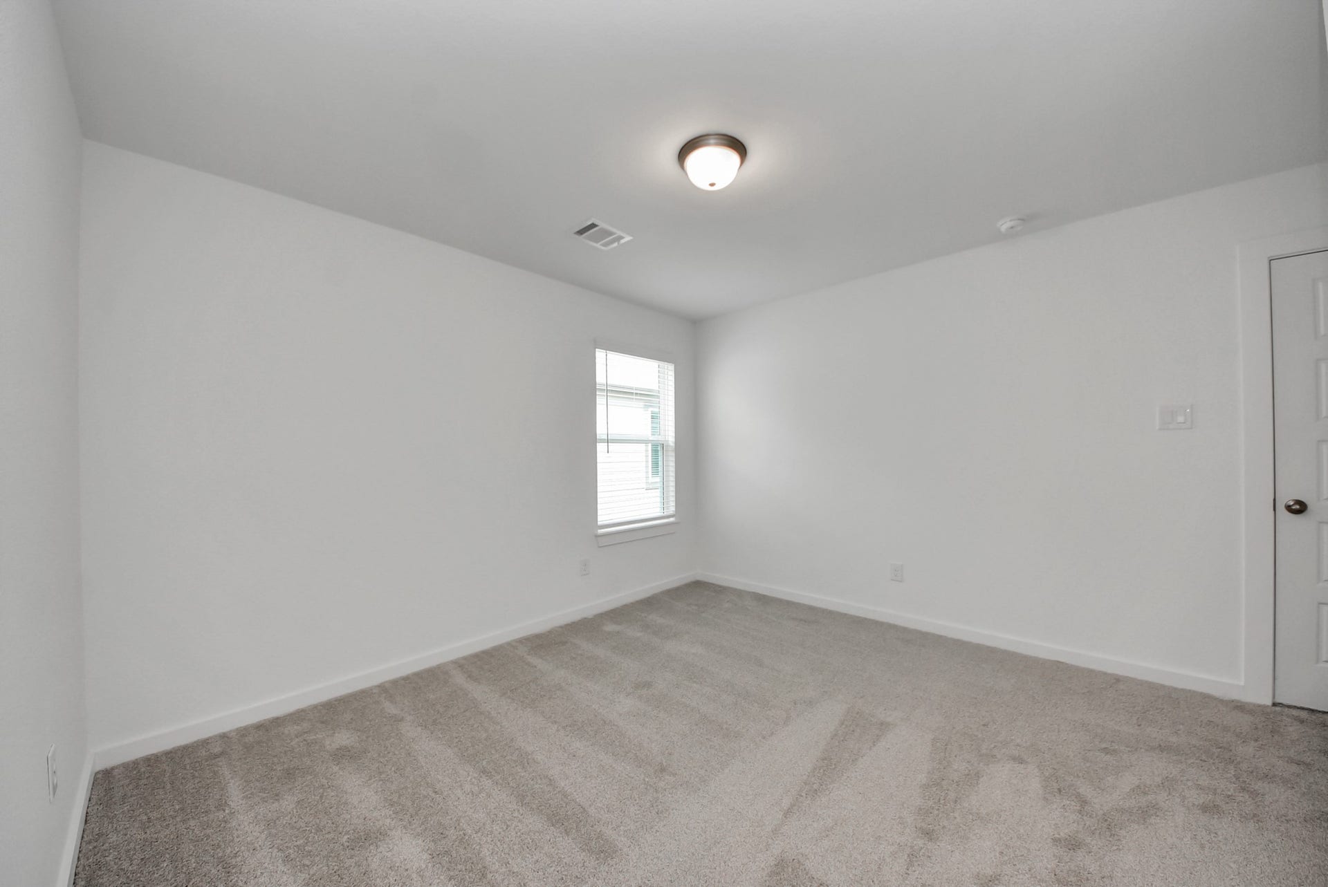 Secondary bedroom features plush carpeting, large windows that let in plenty of natural light, bright paint, and spacious closets.