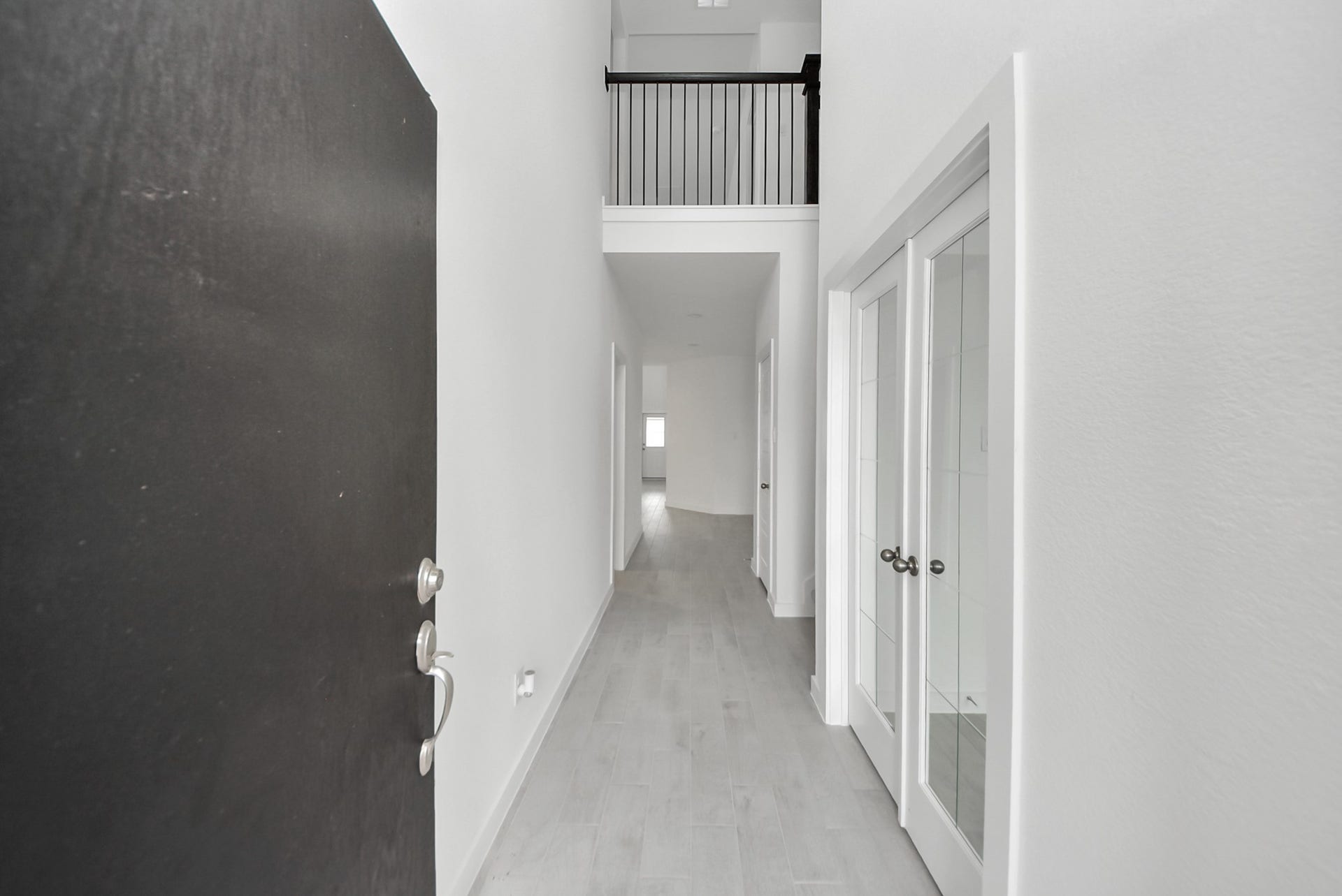 As you step into the threshold of this luxurious home, you'll soon be welcomed by an elegant glass door (to be installed). Inside, soaring ceilings amplify the spaciousness, while the refined wood-look tile flooring and oversized baseboards exude sophistication and charm.