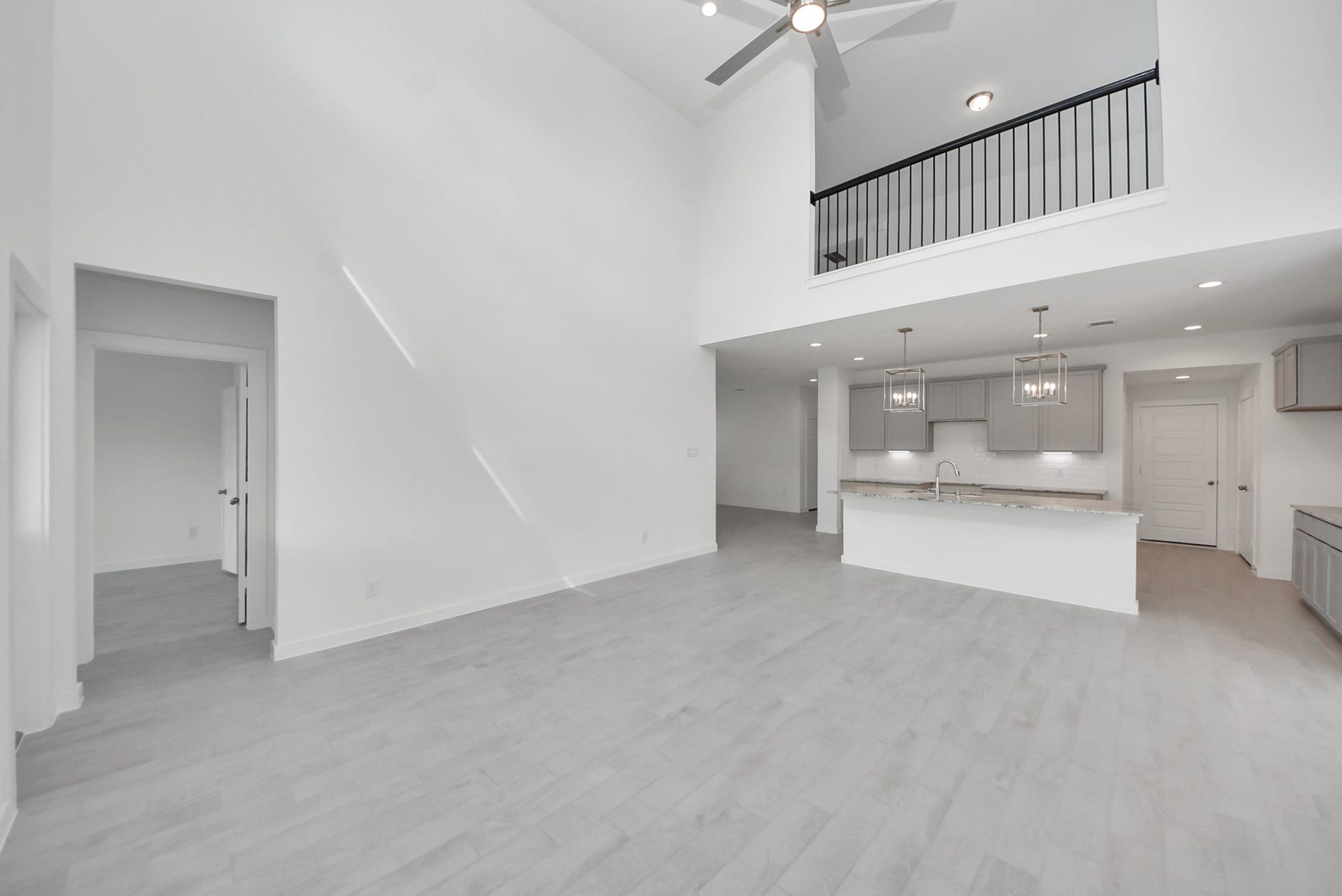 Welcome family and guests to your charming living room! With its high ceilings, recessed lighting, ceiling fan, custom paint, beautiful flooring, and large windows that let in abundant natural light, this room is perfect for gatherings.