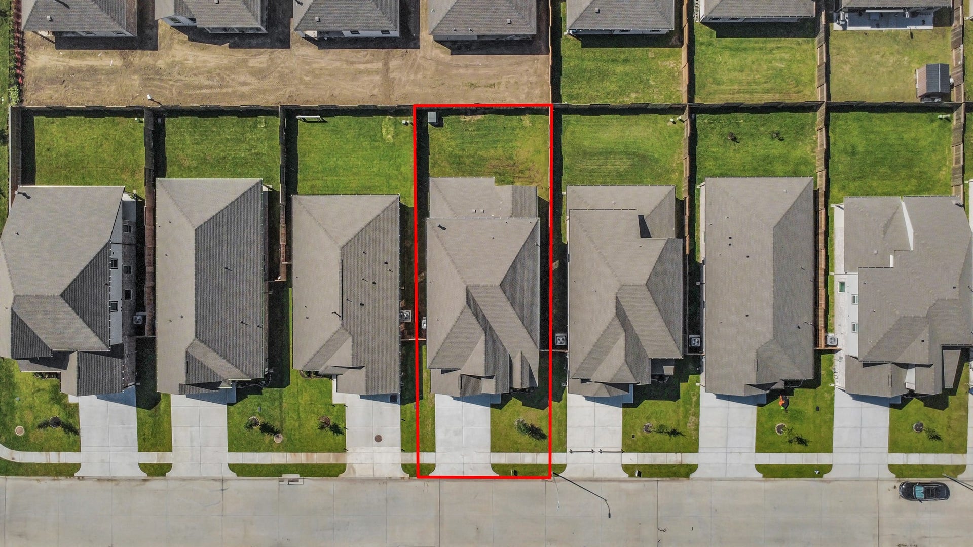 An aerial view of a spacious subdivision lot, highlighting a well-maintained yard and a fully fenced perimeter, offering both privacy and expansive outdoor space.